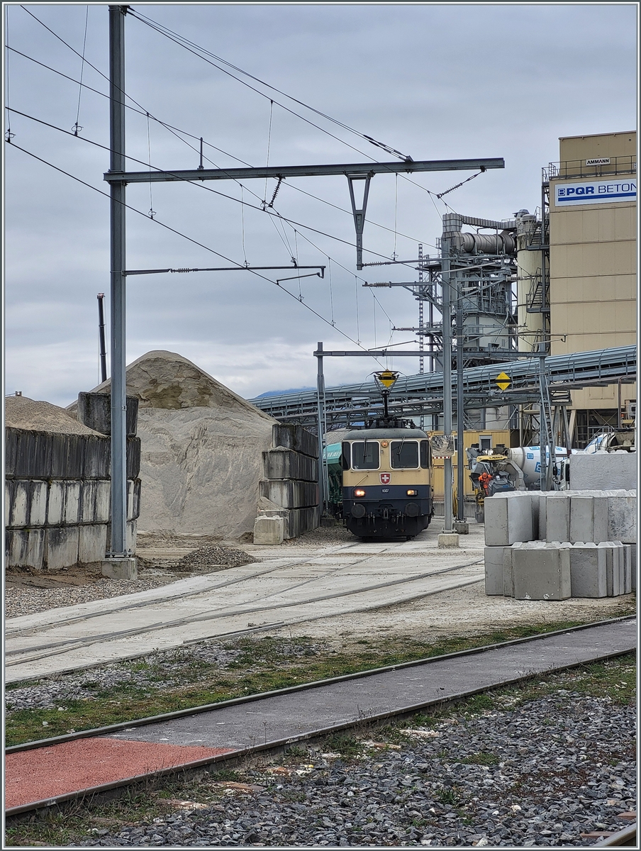 Die IRSI  Rheingold  Re 4/4 II 11387 (Re 421 387), welche die in Revision weilende BAM MBC Re 4/4 II 506 z.Z ersetzt, steht im Kieswerk. Dort wir ihr Zug nach Apples für die Abfahrt vorbereitet.

4. März 2024