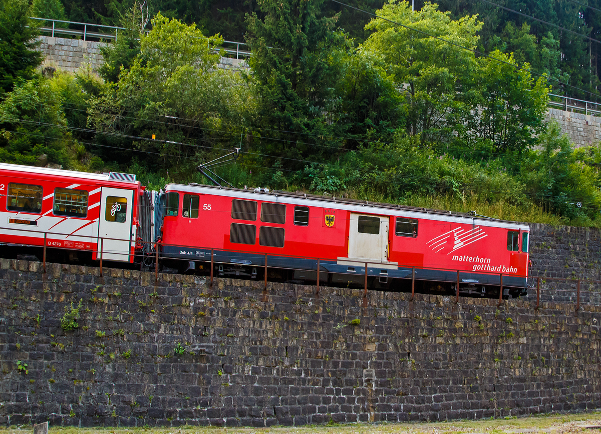 
Die MGB Deh 4/4 – 55 „Brig“ erreicht mit einem Schöllenenbahnzug von Andermatt am 01.08.2019 Göschenen.

Der Gepäcktriebwagen wurde 1972 gebaut, der Lokomotivkasten ist von SIG, die Triebdrehgestelle von SLM und die elektrische Ausrüstung von BBC.

Da das Rollmaterial in den 60er Jahren großenteils veraltet und der Verkehr in der Wintersaison stark angestiegen war, benötigte die FO dringend leistungsfähigere Triebfahrzeuge. Man entschied sich für leistungsfähige Gepäcktriebwagen, die freizügig auf dem gesamten Netz eingesetzt werden konnten. Die fünf Fahrzeuge des Typs Deh 4/4 wurden 1972 bestellt und lösten die HGe 2/2 und die ABDeh 2/4 ab, die den Wintersportverkehr auf der Schöllenenbahn nicht mehr bewältigen konnten. 

Ein Nachbau der FO-Deh 4/4 erhielt einen völlig andersartigen Kasten, weshalb diese Fahrzeuge bei der FO als Deh 4/4 I und II unterschieden wurden. Seit der Fusion zur MGB ist diese Bezeichnung nicht mehr gebräuchlich, die MGB unterscheidet die Serien nach den Nummernbereichen 21, 51 und 91. Wobei sie sich schon optisch und auch technisch etwas unterscheiden.

Technische Daten Deh4/4 I (51-55):
Spurweite: 1.000 mm
Achsformel: Bo'zz Bo'zz
Länge über Puffer: 16.900 mm
Größte Breite: 2.650 mm
Größte Höhe (bei abgesenkten Stromabnehmer): 3.880 mm
Leergewicht: 48,3  t 
Dienstgewicht: 50,3 t
Maximale Zuladung: 2,0 t
Höchstgeschwindigkeit: Adhäsion 60 km/h / Zahnstange 30 km/h
Stundenleistung: 1.032 kW
Dauerleistung: 936 kW
Treibraddurchmesser:  790 mm (Adhäsion) / 688 mm (Zahnrad)
Stromsystem: 11 kV 16,7 Hz AC
Anzahl der Fahrmotoren: 4
Größe der Ladefläche: 11,5 m²