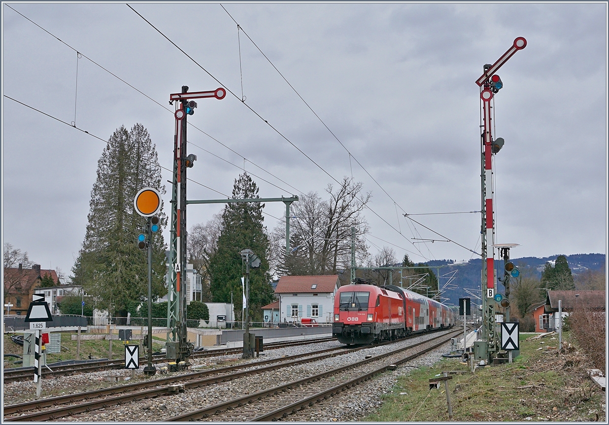 Die ÖBB 1116 098 nähert sich von Bregenz kommend dem Einfahrvorsignal von Lindau Hbf, während die Form Haupt- und Vorsignale von Lindau Reutin von der Gegenseite her das Bild zieren.
14. März 2019