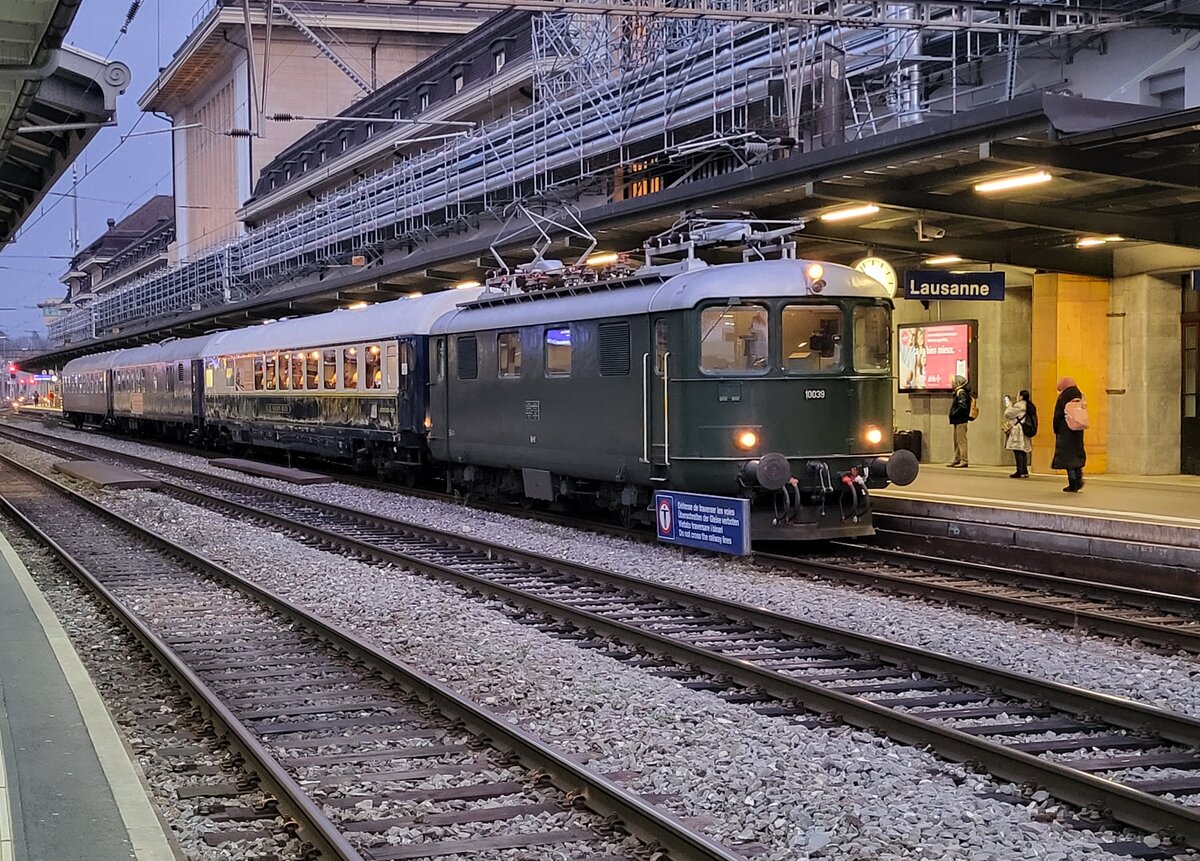 Die Re 4/4 I 10039 stellt den Extrazug 31131 in Lausanne bereit. Der Zug verkehrt für eine Reisegruppe nach Zürich Enge (mit Halt in Palézieux). 

Der Zug besteht aus dem  Le Salon Bleu  61 85 80-90 200-6 CH-IRSI, dem 56 80 89-80 010-2 WGm D-IRSI und dem Am 56 80 10-40 360-4 D-IRSI.

Da der TEE Rheingold Genève - Amsterdam am Schluss seiner Einsatzzeit vor vielen Jahren aus einem DB Speisewagen, einem DB Abteilwagen und einen DB Großraumwagen bestand und auch von einer Re 4/4 I gezogen wurde, weckt der heutige Zug doch Erinnerungen an den TEE 6 / 7, der am 23. Mai 1982 zum letzten Mal ab Genève fuhr, und sich dann noch gut zwei Jahre auf dem Abschnitt Basel - Amsterdam hielt.
    
11. Dezember 2024