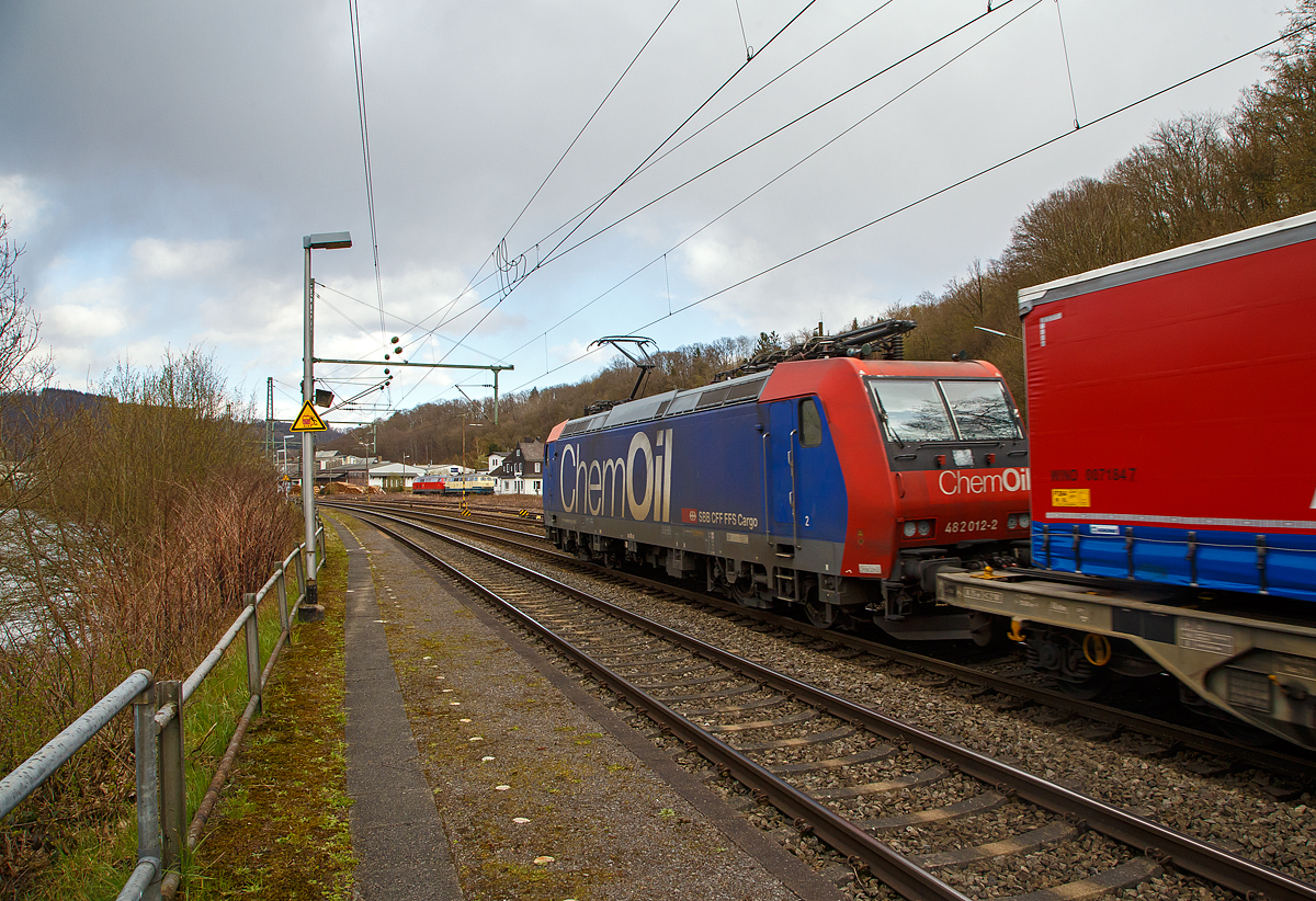 Die Re 482 012-2 „ChemOil“ (91 85 4482 012-2 CH-SBBC) der SBB Cargo AG fährt am 09.04.2022, mit einem „Winner“-KLV -Zug durch Scheuerfeld (Sieg) in Richtung Siegen. Links im Bild kann man die Sieg (Fluss) erkennen, die der Strecke (Siegstrecke) den Namen gibt und oft auf der Fahrt zwischen Siegburg und Siegen überquert wird.

Die TRAXX F140 AC1 wurde 2002 von Bombardier in Kassel unter der Fabriknummer  33527 gebaut und an die SBB Cargo AG geliefert. Sie hat die Zulassungen und Zugbeeinflussungssysteme für die Schweiz und Deutschland. Zurzeit ist sie an die SBB Cargo International AG vermietet.
