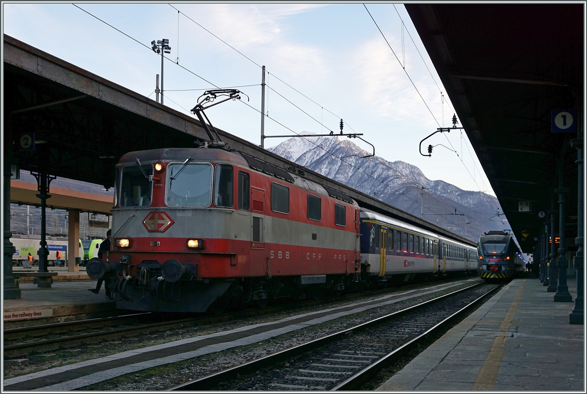 Die SBB Re 4/4 II 11109 wartet in Domodossla mit ihrem IR 3330 nach Brig auf die Abfahrt.
1. M�rz 2016