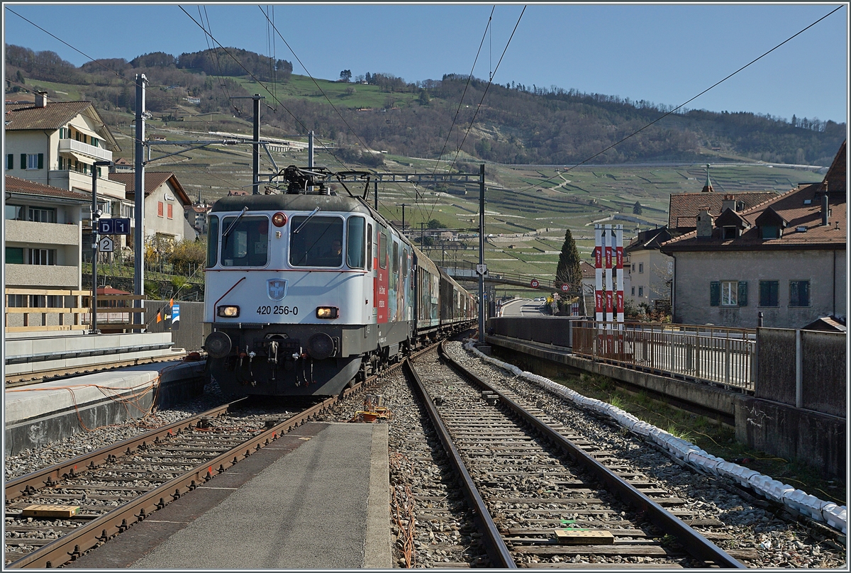 Die SBB Re 4/4 II 11256 (Re 420 256-0) erreicht mit einem Güterzug den Bahnhof von Cully.

1. April 2021