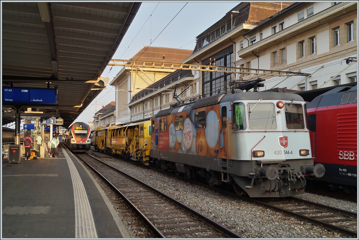 Die SBB Re 4/4 II 11344 (Re 420 344-4 / UIC 91 85 4420 344-4 CH SBBC) mit einer Gleisbaumaschine die auf den Namen  Hummel  hrt. bzw. mit D-Krebs 99 80 91 24 011-4 beschriftet ist, beim Abwarten auf die Weiterfahrt in Lausanne. 

17. April 2021