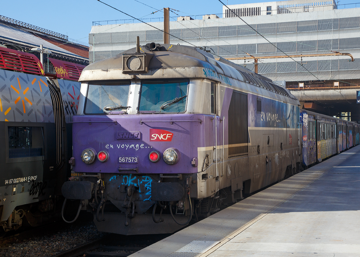 
Die SNCF  en voyage  BB 67573 (567573) steht am 26.03.2015 mit einem Regionalzug im Bahnhof Marseille Saint-Charles. Die erste Zahl vor der Loknummer gibt an welchen Geschäftsbereich der SNCF die Lok zugeordnet ist, hier „5“ = TER.

Zur Beschleunigung des Traktionswandels beschaffte die SNCF ab 1963 bei Brisonneau & Lotz/MTE (Matériel de traction électrique) eine mittelschwere vierachsige Lok mit dieselelektrischer Leistungsübertragung zum Einsatz sowohl vor Reise- wie auch vor Güterzügen. Da die neue Baureihe BB 67000 auf den meisten SNCF-Strecken verkehren sollte, musste ihr Gewicht so niedrig wie möglich gehalten werden. Daher wurde beim mechanischen Teil in großem Maße auf Leichtmetall- und Kunststoffteile zurückgegriffen. Kernstück ihres Antriebs war ein Dieselmotor vom Typ SEMT Pielstick V16 PA4 mit einer Leistung von 1.472 kW, angeflanscht an diesen Motor war ein Gleichstromgenerator, welcher die beiden Gleichstromfahrmotoren des Typs SW 9209 680 mit Energie versorgte. Auf die beiden Radsätze eines jeden, von der BB 9400 adaptierten „Monomoteur“-Drehgestells wirkte jeweils ein Fahrmotor über ein spezielles Getriebe mit zwei Übersetzungsverhältnissen (für 90 und 135 km/h).

Da die BB 67000 weder mit einer Dampfheizung noch einer elektrischen Heizung ausgestattet waren, ließ die SNCF die BB 67036 in den Jahren 1965/66 mit einem Drehstromgenerator ausrüsten, welcher mit Hilfe einer Doppelsternschaltung die beiden Fahrmotoren mit Strom versorgte. Am Generator konnte nun auch die Heizspannung für die elektrische Wagenheizung abgegriffen werden und so stand einem Reisezugeinsatz nichts mehr im Wege. Am 1. Mai 1966 wurde die BB 67036 in BB 67291 umgezeichnet und diente fortan als Prototyp für die kurz darauf bestellte Baureihe 67300. Sie waren bevorzugt für den Reisezugeinsatz gedacht und für eine etwas höhere Geschwindigkeit ausgelegt. Zwischen Dezember 1967 und November 1969 lieferten BL/MTE insgesamt 70 Exemplare aus. Der Motor blieb derselbe, seine Leistung konnte jedoch auf 1.765 kW gesteigert werden. Die elektrische Energie für Fahrmotoren und Wagenheizung erzeugte nun ein angeflanschter Drehstromgenerator. Wie die BB 67000 erhielten auch die BB 67300 eine Doppeltraktionssteuerung eingebaut. 

Weitgehend identisch mit den BB 67300 lieferten BL/MTE zwischen August 1969 und Oktober 1975 insgesamt 232 Exemplare der Baureihe BB 67400 aus, welche sich im Wesentlichen nur durch eine geänderte Drehgestellkonstruktion von der Ursprungsausführung unterschieden. Die neu konzipierten Drehgestelle besaßen nun einen Radsatzstand von 2.500 mm (statt vorher 2.400 mm) und die Sekundärfederung bestand nun aus Federn und Silentblöcken. Zudem haben sie anderen Fahrmotoren und zwar zwei CTS 66.43.4 1460 V fremdbelüftete Antriebe.

Zwischen 1975 und 1979 wurden noch 20 Maschinen der Ursprungsbaureihe BB 67000 in BB 67300 umgebaut. insgesamt 80 weitere BB 67000 zeichnete die SNCF zwischen 1980 und 2007 in die Baureihe BB 67200 um. Sie wurden auf den neuen TGV-Strecken für Bau- und Arbeitszugdienste sowie zum Abschleppen liegengebliebener TGV verwendet. Hierfür installierte man die für Schnellfahrstrecken notwendige Führerstandsignalisierung TVM 300 oder TVM 430 sowie teilweise eine Scharfenberg-Hilfskupplung. Die restlichen 24 Exemplare der BB 67000 mussten in den Jahren 2002 bis 2004 alle den Dienst quittieren. Die verbliebenen Baureihen stehen hingegen noch in großer Stückzahl in Betrieb. Während die BB 67200 ausschließlich SNCF-lnfra zugeordnet sind, kommen die beiden anderen Reihen bei allen SNCF-Sparten wie CiC, FRET, IDF, lnfra, TER und im Pariser Vorortverkehr Transilien zum Einsatz.


Technische Daten der SNCF BB 67400
Anzahl:  232 (Anfang Dez. 2015 noch 134 Maschinen in Betrieb)
Spurweite:  1.435 mm (Normalspur)
Achsformel:  Bo'Bo'
Länge über Puffer:  17.090 mm
Breite: 2.940 mm
Höhe: 4.140 mm
Drehzapfenabstand: 9.800 mm
Achsabstand im Drehgestell: 2.500 mm
Dienstmasse:  83,3 t
Radsatzfahrmasse:  20,8 t
Höchstgeschwindigkeit: 140 km/h
Installierte Leistung:  1.765 kW
Treibraddurchmesser:  1.260 mm
Dieselmotor: 16V-Dieselmotor, Typ S.E.M.T. Pielstick 16 PA 4 
Tankinhalt:  3.400 L
Verbrauch: ca. 3 L/km
Antrieb:  dieselelektrisch
Fahrmotoren: 2 Stück fremdbelüftete 1460 V Gleichstrommotoren CTS 66.43.4
Bremse: automatische Druckluftbremse
Zugheizung: elektrisch 1500 V =
Kupplungstyp:  Schraubenkupplung