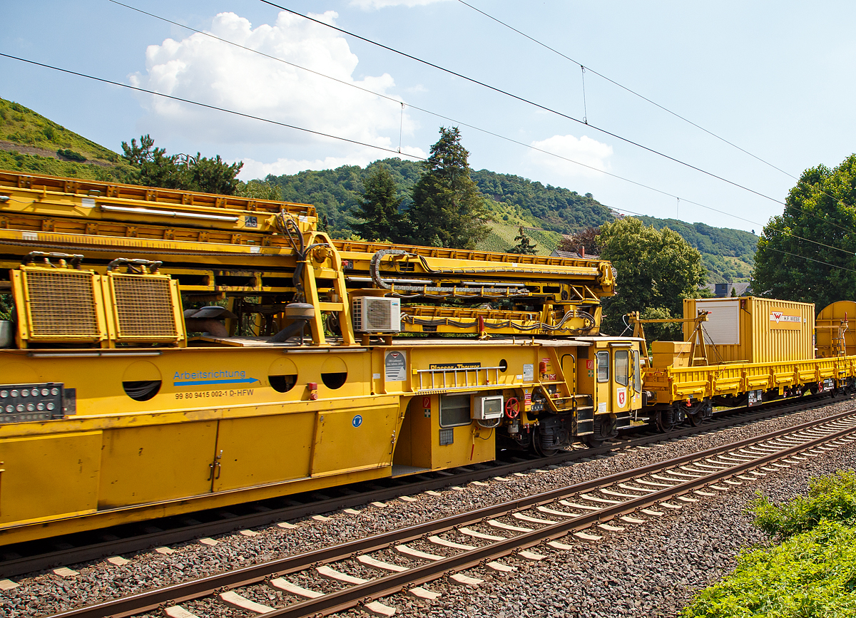 
Die Wiebe Recycling-Planumsverbesserungsmaschine mit Schotterrecycling RPMW 2002-2 am 14.07.2018 im Zugverband auf der Fahrt durch Leutesdorf,  auf der KBS 465 (Rechte Rheinstrecke) in Richtung Norden. 

Über 140 Meter lang, knapp 5 Meter hoch und gute 560 Tonnen schwer – die Gleisbaumaschine RPMW 2002-2 gehört zu den größten der Welt. Mit ihrer beachtlichen Leistung und dem umfänglichen Leistungsspektrum ist sie ein äußerst wichtiger Bestandteil des Maschinenparks der Unternehmensgruppe Wiebe.

Die Recycling Planumsverbesserungsmaschine führt verschiedene Gleisbauarbeiten durch – und das mit einer Motorengesamtleistung von über 2100 Kilowatt. Diese Kraft kommt bei Totalsanierungen zum Tragen, bei denen die RPMW 2002-2 mehrere Arbeitsschritte simultan ausführt: Die verschmutzte Schotterbettung wird ausgebaut, das abgetragene Bettungsmaterial aufbereitet, Schotter recycelt und die Unterbauplanumsschicht erneuert.

TECHNISCHE DATEN:
Hersteller: Plasser & Theurer
Baujahr, Erstzulassung: 2000
Spurweite: 1.435 mm
Anzahl der Achsen: 29, davon 12 angetrieben
Baumaschinennummer: Aushubmaschine 3369, Recyclingmaschine 3368, Antriebswagen 3367,  Stopf- u. Einschotterungsmaschine 3370
Motoren: Caterpillar 
Leistung: 2.860 PS
Gesamtlänge über Puffer: 140,90 m
Breite: 3,29 m
Höhe: 4,65 m
Gewicht: 560 t
V zul. im Zug eingestellt: 100 km/h
V max. bei Eigenfahrt: 20 km/h
Fahrradius: 120 m

Der große Unterschied zwischen Planumsverbesserungsmaschine und Bettungsreinigungsmaschinen besteht darin, dass die Planumsverbesserungsmaschine nicht nur den Schotter ausheben und recyceln kann, sondern auch einen Teil des Planums (Unterbau) ausheben (bis 1.200 mm unter SOK). Zudem kann die RPM vor der Neuschotterung (Recycling- mit Neumaterial) auch eine Planumsschutzschicht (PSS-Material) einbringen.
Der Neuschottern wird durch die Stopfeinrichtung 09-32 Stopfsatellit im Gleisbett verdichtet und das Gleis ist danach wieder mit 70 km/h befahrbar.

Hier im Bild ist der Anfang der Maschine (in Arbeitsrichtung), wo aber nicht der erste Arbeitsschritt beginnt, denn der beginnt an der Schotteraushubkette. Im Betrieb werden Materialförder- und Siloeinheit en (MFS) vor die Maschine gesetzt, zwei Förderbänder der Maschine ausgefahren und der Abraum in die MSF übergeben.