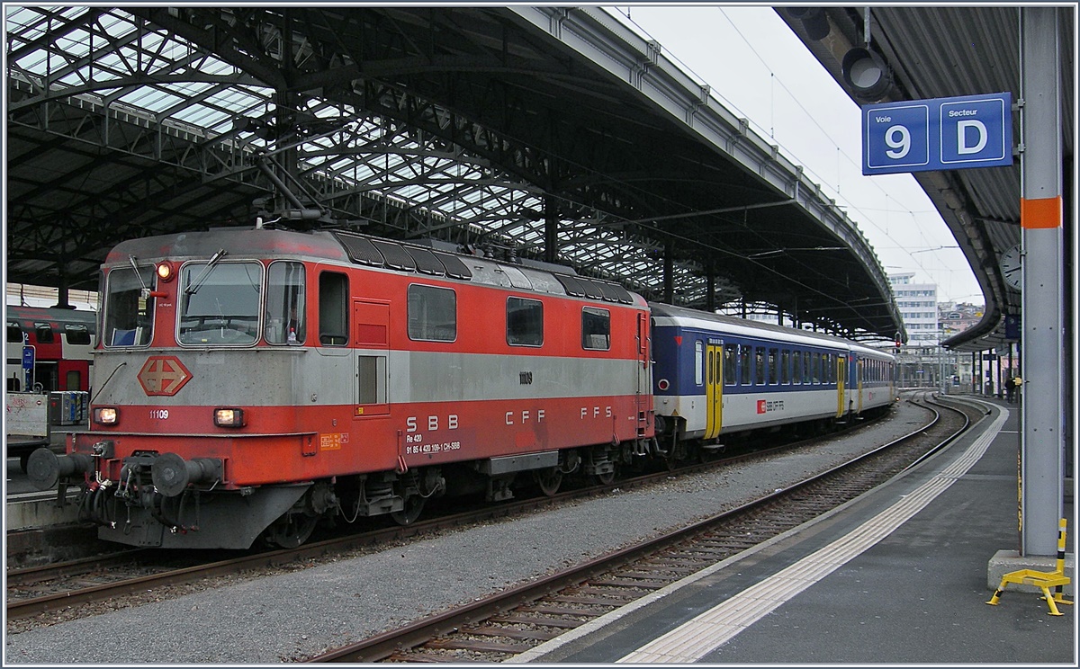 Die Zeit der Re 4/4 II 11109 in der Westschweiz, insbesondere auf der Strecke Genève - Brig neigt sich dem Ende entegegen, da die Strecke Lauanne - Villeneve ab dem 23 April 2017 auf ETCS umgestellt wird.
Auf dem Bild ist die Re 4/4 II 11109 mit eine Dispozug Brig - Genève beim Halt in Lausanne zu sehen. 
9. Jan. 2017