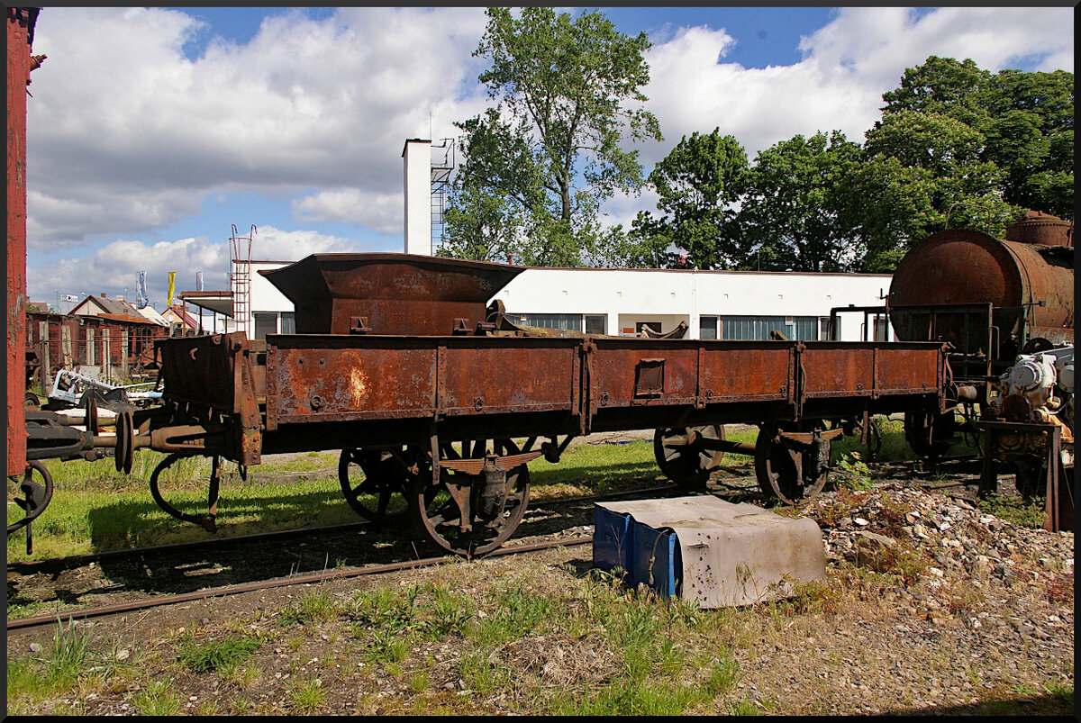 Dieser Niederbordwagen mit Speicenrädern und metallenen Seitenwänden stand am 21.05.2022 im Eisenbahnmusem Jaroměř. Eine Gattung oder Nummer war an dem schon stark angerosteten Wagen nicht mehr erkennbar.