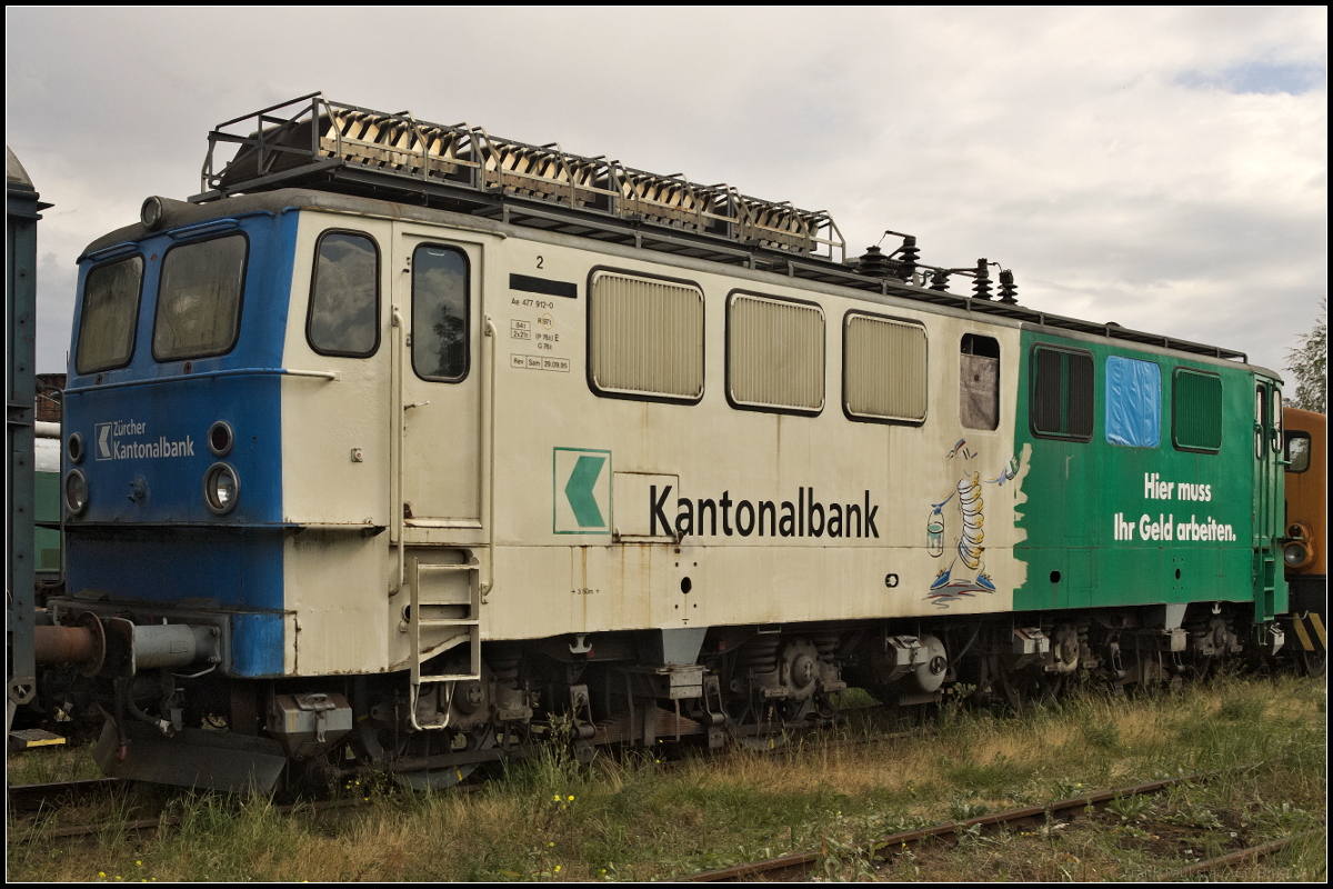 DP 64 / Ae 477 912-0 war einst bei der Mittelthurgaubahn in der Schweiz im Einsatz. Dort erhielt sie die Werbung 'Zürcher Kantonalbank - Hier muss Ihr Geld arbeiten'. Seit 2010 ist die Lok bei Deutsche Privatbahn GmbH und trägt die Nummer DP 64. Am 25.08.2018 konnte die Lok auf einem Abstellgleis am Historischen Lokschuppen in Wittenberge entdeckt werden.