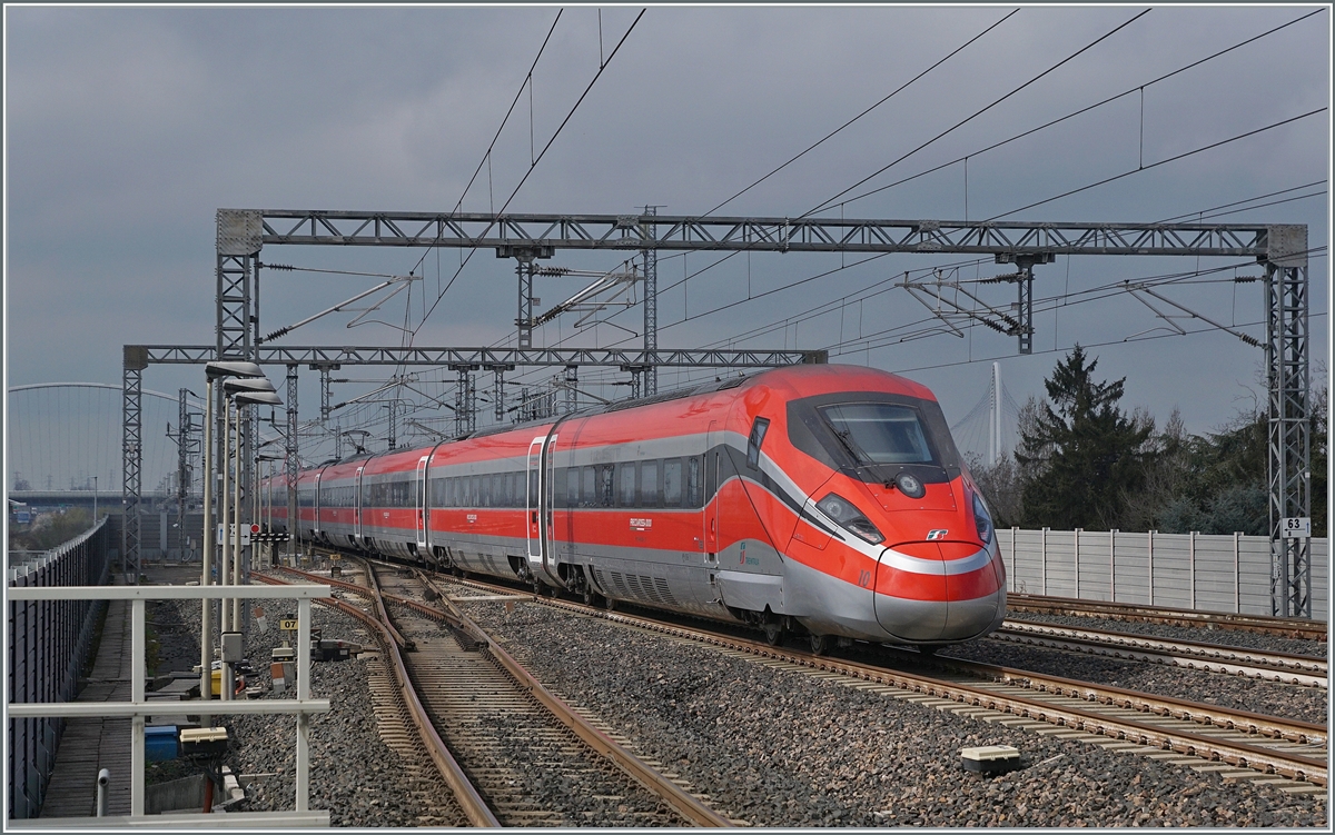 Durch den hier haltenden und etwas verspäteten ETR 500 037 etwas aus gebremst, ist der FS Trenitalia ETR 400 010 als Frecciarossa 1000 FR 9624 von Roma (ab 10:20) nach Milano (an 13:35 etwas weniger schnell unterwegs, als er durch den Bahnhof von Reggio Emilia AV fährt. 

14. März 2023