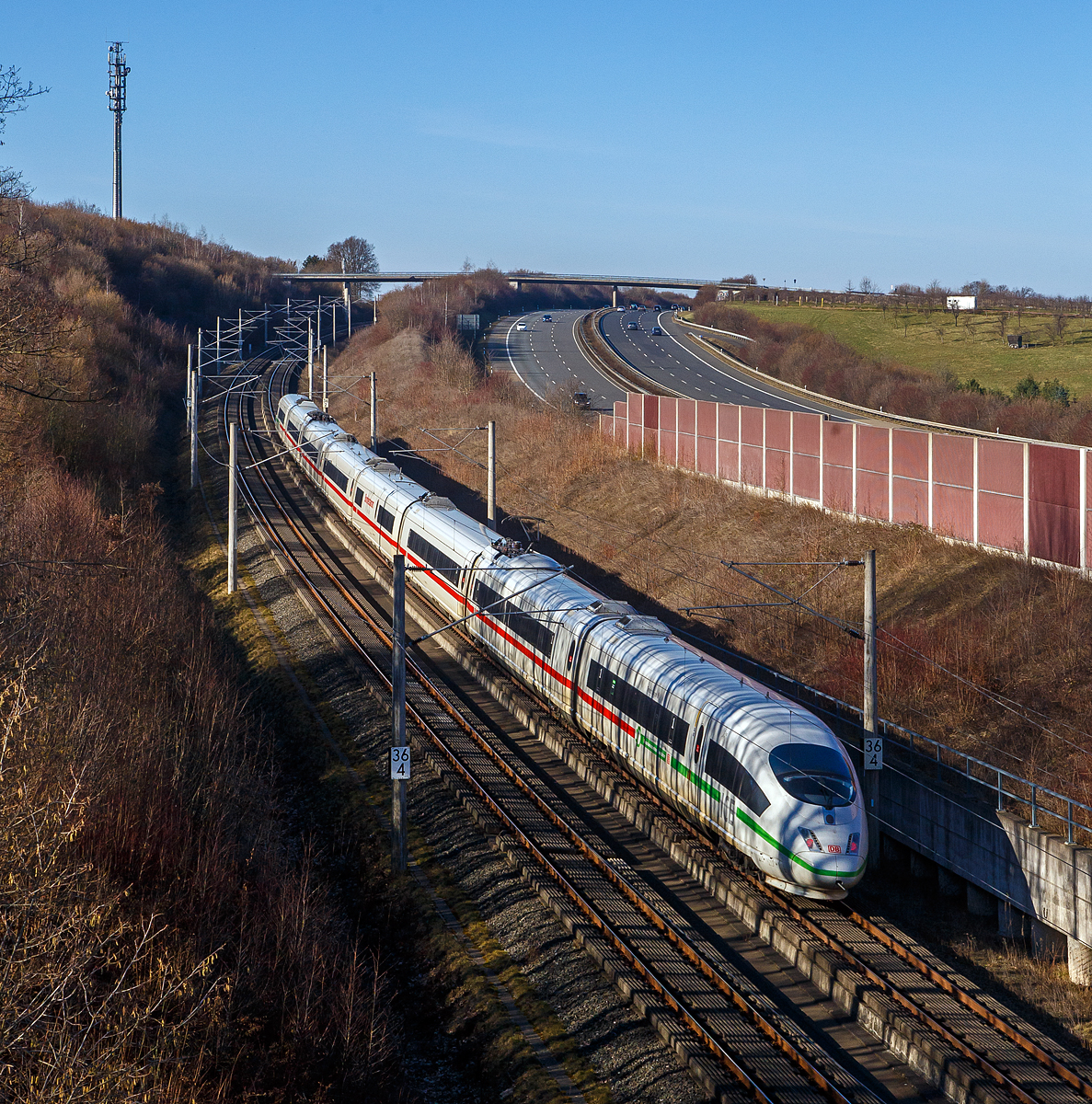 Ein ICE 3 (BR 403) rauscht am 21.02.2021 bei Oberpleis über die Schnellfahrstrecke Rhein/Main (KBS 472) in Richtung Köln. Rechts die Autobahn A 3. Oberpleis ist ein Stadtteil von Königswinter, der auf der dem Rhein abgewandten Seite des Siebengebirges im Pleiser Hügelland liegt.