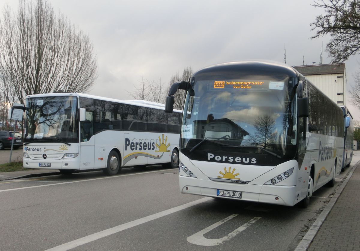 Ein Mercedes-Benz Tourismo RH und ein Neoplan Trendliner N 3516 Ü von Perseus-Reisen aus Neumarkt-St. Veit, hier eingesetzt auf einem Schienenersatzverkehr zwischen Mühldorf/Inn und Ampfing (Bahnstrecke Mühldorf - München). Sie warten gerade am Ampfinger Bahnhof auf die nächste Gruppe Bahnfahrgäste aus München, um diese weiter nach Mühldorf zu befördern.
Die Aufnahme entstand am 2. 4. 2015.