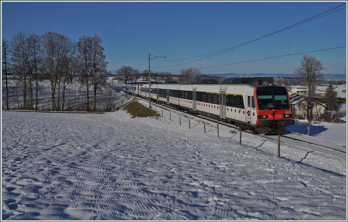 Ein tpf und ein SBB RBDe 560  Domino sind als RE 4016 von D�dingen nach Bulle unterwegs und erreichen in K�rze die Dienst- und Kreuzungsstation Vuisternens-devant- Romont. Weit im Hintergrund ist sogar noch der Jura zu erkennen. 

23. Dezember 2021
