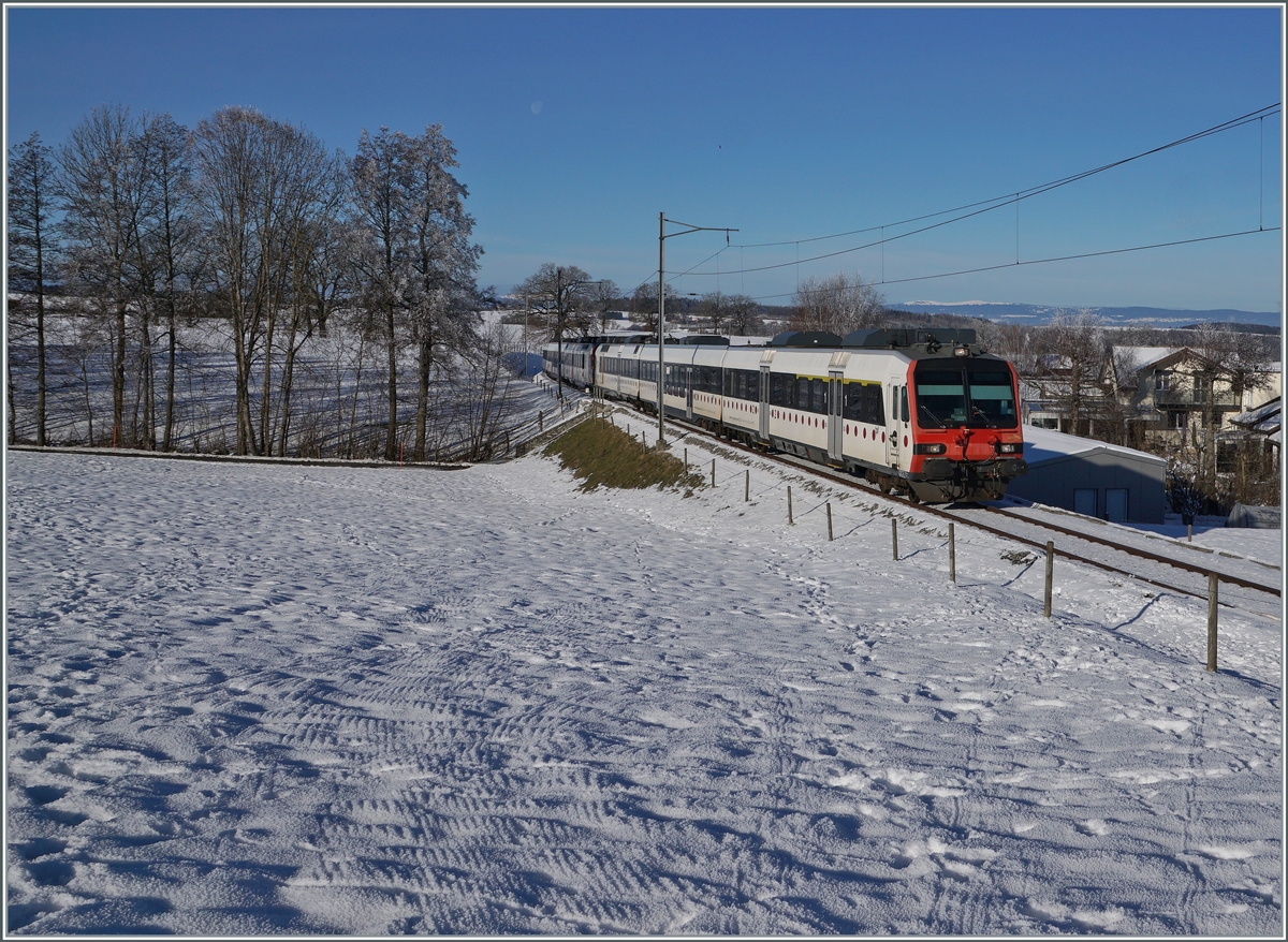 Ein tpf und ein SBB RBDe 560  Domino sind als RE 4016 von Düdingen nach Bulle unterwegs und erreichen in Kürze die Dienst- und Kreuzungsstation Vuisternens-devant- Romont. Weit im Hintergrund ist sogar noch der Jura zu erkennen.

23. Dezember 2021