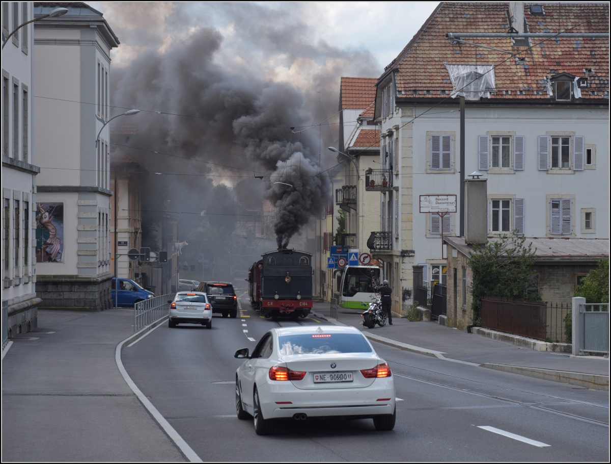 Eine etwas ungewöhnliche Verkehrsteilnehmerin in La Chaux-de-Fonds. 

Rette sich, wer kann. Denn CP E 164, heute bei La Traction, schnaubt mit viel Rauch als Geisterfahrerin die Rue du Manège hinauf. So sammeln sich respektvoll immer mehr Autofahrer auf der falschen Strassenseite. September 2021.