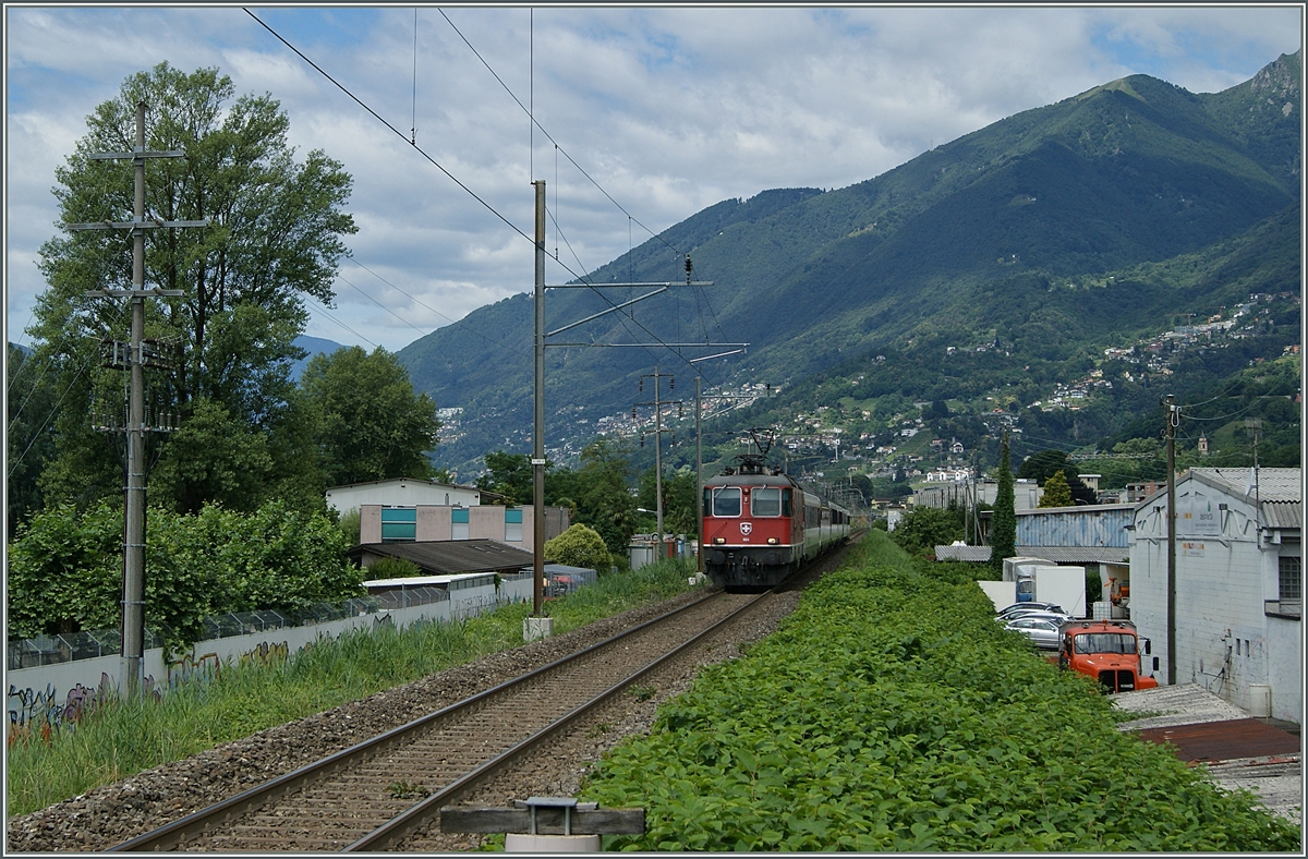 Eine SBB Re 4/4 II erreicht mit ihrem Gotthard IR von Locarno kommend Riazzino.
21. Juni 2016