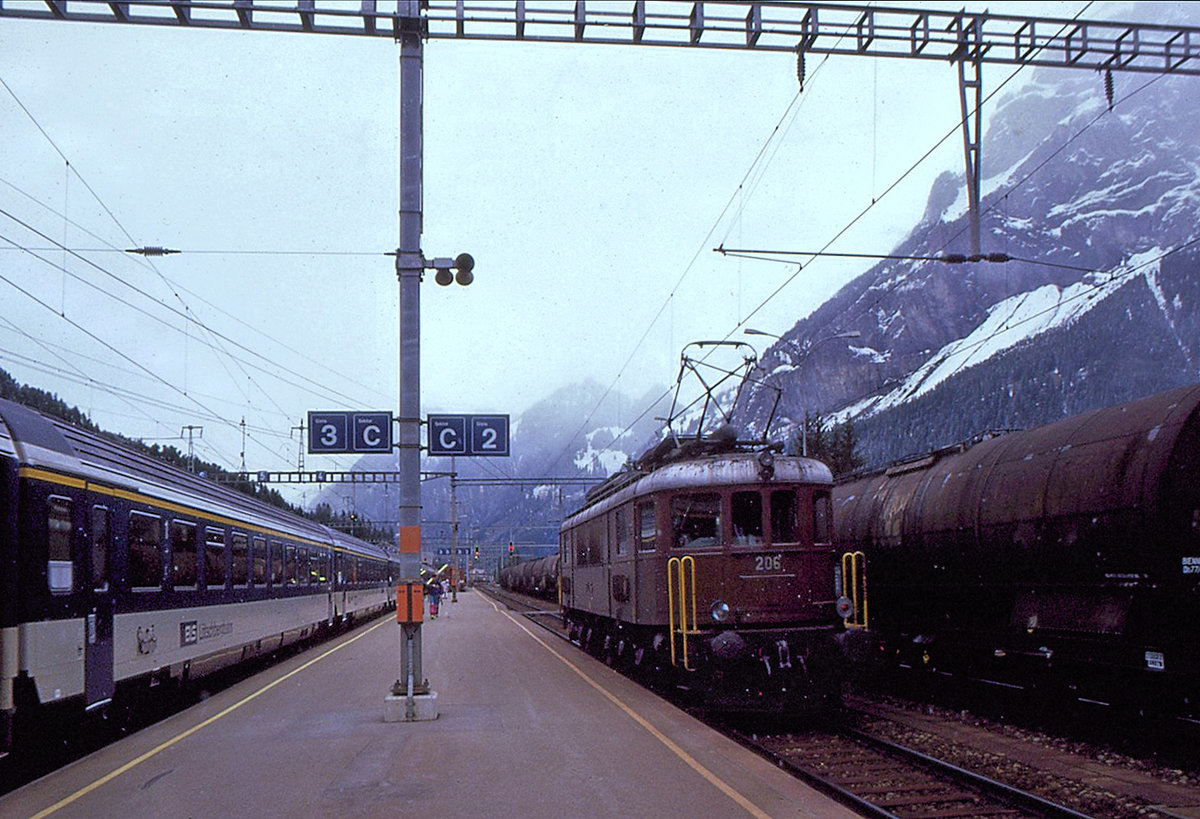 Erinnerung an die eindrucksvollen BLS Ae6/8: 206 in Kandersteg; sie fährt nach einem Schiebedienst wieder nach Frutigen zurück. Links ein damaliger BLS Einheitswagen IV. 8.April 1994 