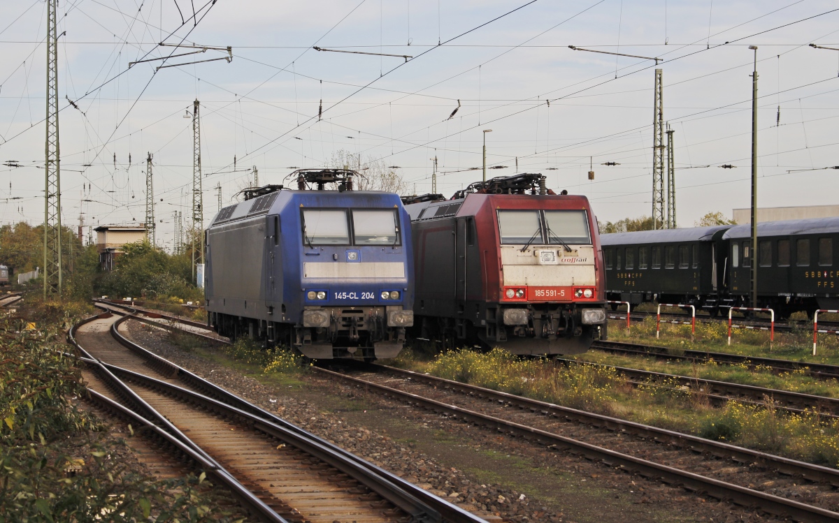 Erinnerungen an die 2018 aufgelöste Crossrail: Die von CB Rail angemietete 145-CL 204 und die 185 591-5 (angemietet von BTMU) warten am 31.10.2013 auf die nächsten Aufgaben. Auch wenn die daneben stehenden schweizer Museumswagen vielleicht einen anderen Eindruck vermitteln, das Foto entstand fern der Heimat am Niederrhein im Krefelder Hauptbahnhof.