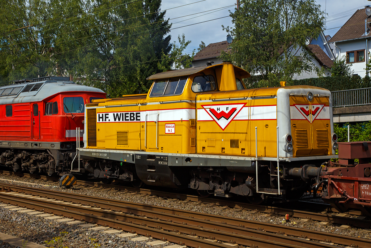 Geschleppt von der Ludmilla 234 278-0 wird die Wiebe Lok 2 bzw. 211 341-3 (92 80 1211 341-3 D-BLP), ex DB 211 341-3, ex DB V 100 1341, am 24.07.2020 von Kreuztal in Richtung Hagen. 

Die V 100.10 wurde 1962 von Arnold Jung Lokomotivfabrik GmbH, Jungenthal bei Kirchen an der Sieg, unter der Fabriknummer 13468 gebaut und als V 100 1341 an die Deutsche Bundesbahn geliefert. Zum 01.01.1968 erfolgte dann die Umzeichnung in DB 211 341-3, als diese fuhr sie bis zur Ausmusterung 1988. Im Jahr 1990 ging sie an die H. F. Wiebe KG, wo sie erst als Lok 1 geführt wurde.
Die V100.10  (BR 211) haben eine12-Zylinder-Viertakt-Dieselmotor  mit etwas geringerer Leistung gegenüber der V 100.20. Da die V 100.10 (BR 211) für den leichten Reise- und Güterzugdienst auf Nebenstrecken vorgesehen war. Bei den V 100.10 kam überwiegend der Maybach MD 650 1B und der Daimler-Benz MB 820 Bb zum Einsatz, seltener war der MAN L 12 V 18/21 zu finden. Die Nennleistung lag bei 809 kW (1100 PS).

TECHNISCHE DATEN:
Spurweite: 1.435 mm
Achsfolge: B'B'
Eigengewicht: 63,0 t
Länge über Puffer: 12.300 mm
Drehzapfenabstand: 6.000 mm
Achsstand im Drehgestell: 2.200 mm
größte Breite: 3.115 mm
größte Höhe über Schienenoberkante: 4.275 mm
kleinster befahrbarer Gleisbogen: 100 m
Treibraddurchmesser: 950 mm
Höchstgeschwindigkeit: 100 km/h
Antrieb: dieselhydraulisch
Leistung: 809 kW (1.100 PS)
Nenndrehzahl: 1.500 U/min
Anfahrzugkraft: 177 kN
Kraftübertragung: hydraulisch
Kupplungsart: Schraubenkupplung
