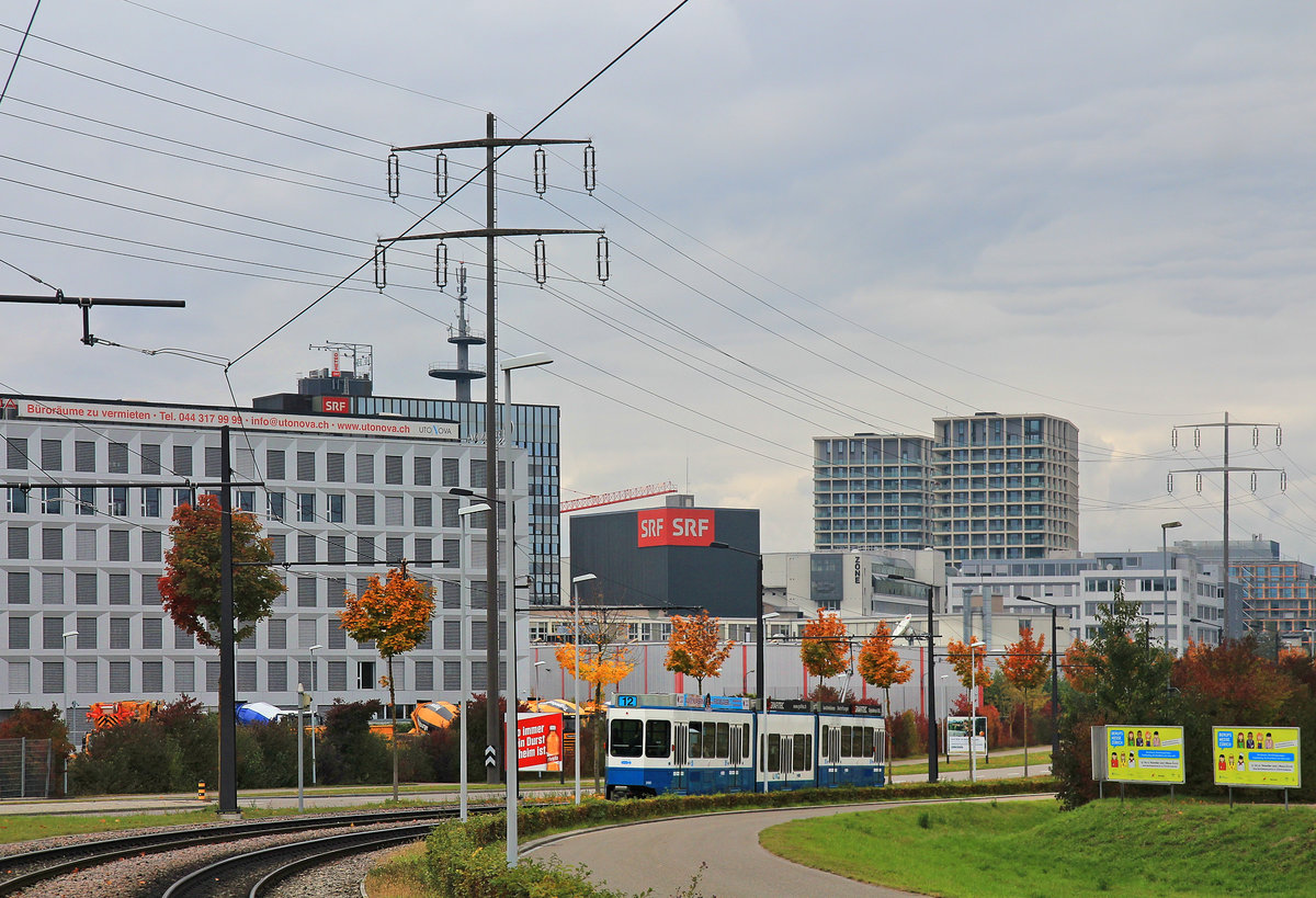 Glattalbahn, Tram 2000 Nr. 2100 braust von Auzelg am Fernsehstudio vorbei Richtung Glattpark. Auf dem Fernsehstudio erkennt man das berühmte Meteodach, von dem aus jeden Abend die Wettervorhersage gesendet wird. 17.Oktober 2020 