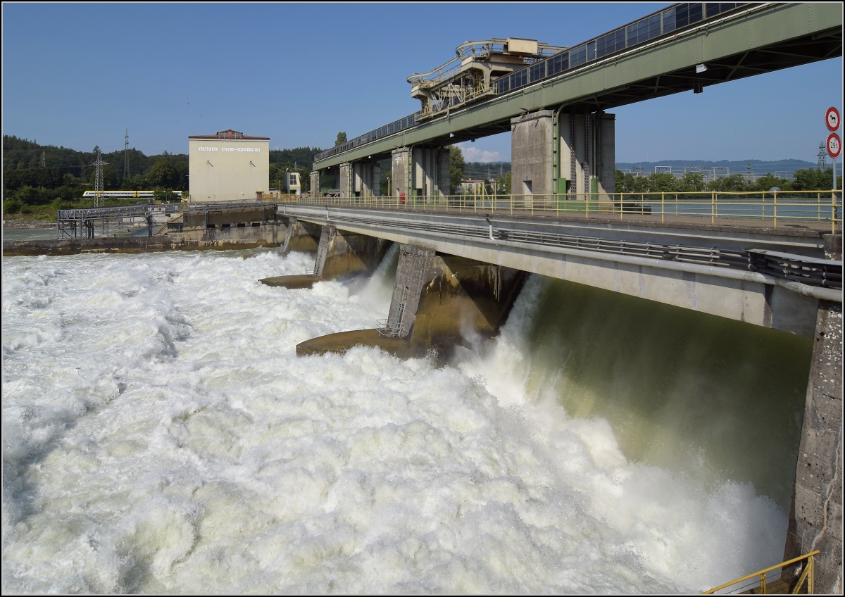 Hochwasser am Hochrhein.

Durch die Flutwehre des Kraftwerk Ryburg-Schwörstadt rauscht mehr Wasser am Kraftwerk vorbei (Aufnahmezeitpunkt ca. 1000 m²/s), als am Rheinfall zur gleichen Zeit herunterstürzt. Entsprechend laut ist das Getöse. Trotzdem hört man den 612 auf der deutschen Seite ganz deutlich. Möhlin, Juli 2021. 