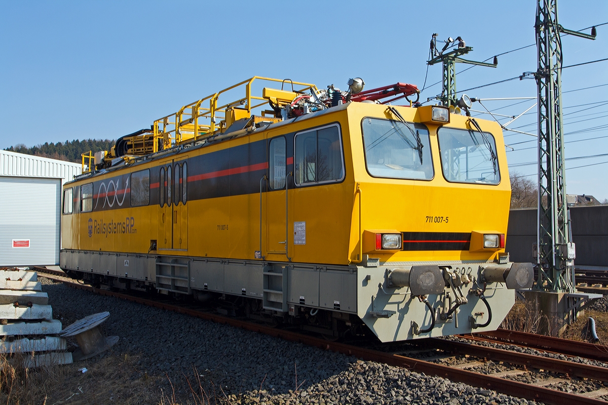 
Hubarbeitsbühnen-Instandhaltungsfahrzeug für Oberleitungsanlagen (HIOB) 711 007-5 der RAILPOOL RAILSYSTEMS RP GmbH (ex DB Netz AG 711 007-5), abgestellt am 07.04.2014 beim ICE-Bahnhof Montabaur.

Bei der Baureihe 711.0 handelt es sich um neun, in den Jahren 1995 und 1996 von Windhoff in Rheine gebaute Fahrzeuge zur Entstörung und Instandhaltung von Oberleitungsanlagen. Als Nachfolger für die älteren Turmtriebwagen bestellte die DB Netz bei der Firma Windhoff neun solcher Fahrzeuge.

Die Triebwagen der Baureihe 711.0 besitzen einen über die gesamte Rahmenlänge reichenden Wagenkasten in Stahlleichtbauweise. Der Wagenkasten beinhaltet einen 8.060 mm langen Werkstattraum, den Führerstand 1 mit 2.400 mm Länge und den kombinierten Aufenthaltsraum mit Führerstand 2, hier befinden sich auch der Videoarbeitsplatz und das Vakuum WC.

Auf dem Dach der Kabine befinden sich, angefangen über dem Führerstand 1, ein Messstromabnehmer der Bauart WBL 85 dessen Anpressdruck manuell regelbar ist, es folgt die Fahrdraht- und Tragseilhebeeinrichtung von dem Hersteller Atlas, anschließend ist eine Hubarbeitsbühne mit den Abmessungen 3.500 mm x 1.600 mm vorhanden, diese kann hydraulisch um 1.400 mm angehoben werden. Mit der Hubarbeitsbühne kombinierbar ist die freischwenkbare Hubarbeitsbühne, mit den Abmessungen 1.500 mm x 1.600 mm. Beide Bühnen erreichen im Gleichlauf eine maximale Höhe über SO von 5.200 mm, die freischwenkbare Hubarbeitsbühne alleine bis zu 20 m. Zuletzt ist noch eine Videokamera vorhanden, welche ein Bild des angelegten Stromabnehmers an den Videoarbeitsplatz sendet, von wo aus die Aufzeichnungen in Echtzeit kommentiert werden können.

Die  HIOB  verfügen über ein Lauf- und ein Triebdrehgestell, beide sind annähernd baugleich und besitzen zwei durch Megifedern geführte Achsen mit Monoblockrädern. Verzögert werden die Fahrzeuge durch eine Motor- und eine Druckluftbremse. Die selbsttätige indirekte und die nichtselbsttätige direkte Druckluftbremse wirken jeweils auf Graugussbremsklötze an allen Achsen, beide Bremsen sind mehrlösig. Zum Festhalten des stehenden Fahrzeugs ist eine elektropneumatisch gesteuerte Federspeicherbremse vorhanden.

Für die Streckenfahrt ist ein 6-Zylinder-MAN-Dieselmotor mit Abgasturbolader und Ladeluftkühlung vom Typ D 2876 LOH 01 vorhanden, dieser hat eine Leistung von 338 kW (460 PS) bei 1.800/min. Die Leistungsübertragung geschieht über ein hydrodynamisches Getriebe auf beide Achsen des Triebdrehgestells. 
Für die Arbeitsfahrt bzw. für den Antrieb der Hydraulikpumpe wurde ein 4-Zylinder-MAN-Dieselmotor vom Typ D 0824 LFL 02 mit 118 kW (160 PS) bei 2.400/min verbaut. Der erzeugte Öldruck treibt unteranderem einen in den Antriebsstrang eingebauten Hydraulikmotor an. Durch diese Bauweise ist es möglich für Streckenfahrt, mit höherer Geschwindigkeit, beide Motoren parallel zu betreiben, um so eine recht hohe Leistung zu erhalten. 

Für den Betrieb sind zwei Stromsysteme installiert. Zur Nutzung von handelsüblichen Werkzeugen ist ein Drehstromnetz 230/400 V mit 10 kVA vorhanden. Das gesamte Fahrzeug wird durch ein 24 V-Netz betrieben, das seine Energie aus Batterien und, von den Motoren angetriebene, Lichtmaschinen bezieht. Des Weiteren können die Batterien über einen 230 V-Fremdspannungsanschluss geladen werden. 

Gesteuert wird das Fahrzeug über eine integrierte Fahrzeugsteuerung von Krauss-Maffei, diese übernimmt die Regelung, Überwachung und Diagnose aller relevanten Funktionen. Antriebs- und Bremsbefehle werden über einen, auf dem Führerpult integrierten, kombinierten Fahr-/Bremshebel erteilt. Für deutsche Triebfahrzeuge fast selbstverständlich sind herstellerseitig eine Indusi I 60R, eine Zeit/Zeit Sifa und Zugfunk. Außerdem haben die Fahrzeugen 711 007 bis 009 eine LZB 80 eingebaut. 

Das Fahrzeug, wie auch 711 002 und 009, wurde 2009 von der DB Netz AG an die Railsystems RP GmbH verkauft.

Seine technischen Möglichkeiten:
- frei um ca.330° schwenkbare Hubarbeitsbühne mit eine Auslegung von 20 m Höhe und bis 12 m seitlich (z.B. 18 m auf 8 m seitlich)
- Scherenhub- und Montagebühne Länge 5,00 m, Arbeitshöhe Bühnenboden: 3,80 ࠓ 5,20m üSO
- Fahrdraht- und Tragseilanhebevorrichtung bis 8,0m üSO, seitliche Verschiebbarkeit 600 mm
- Meßstromabnehmer zur Messung der Fahrdrahtlage und Kettenwerke mit Videoaufzeichnung, nach Umbauarbeiten
- Abgasfilter für Tunnelarbeiten
- Arbeits- und Revisionsfahrt 0,5 - 10 km/h
Somit besitzt das Fahrzeug alle notwendigen Anlagen zur Oberleitungsmontage, Instandhaltung und Havariebeseitigung. 


Technische Daten:
Hersteller: Windhoff Bahn- und Anlagentechnik GmbH, Rheine
Fabriknummer: 2433 (am Fahrzeug konnte ich jedoch 160 727/7 lesen)
Baujahr: 1996
EBA-Nummer: EBA 95S02M 007

Spurweite: 1.435 mm
Achsformel:  2'B'
Länge über Puffer: 17.240 mm
Höhe:  4.680 mm (Grundstellung der Geräte)
Breite:  3.000 mm
Drehzapfenabstand:  11.000 mm
Drehgestellachsstand:  1.800 mm
Leergewicht:  61,0 t
Dienstgewicht:  66,0 t
Radsatzfahrmasse:  max. 16,5 t
Nutzlast:  5 t      
Zul. Anhängelast:  80 t     
Höchstgeschwindigkeit:  120 km/h
Zul. Schleppgeschwindigkeit: 140 km/h
Zur Mitfahrt zugel. Personen: 12
Zugelassene Streckenklasse: B2 oder höher
Traktionsleistung:  6-Zylinder-MAN-Dieselmotor mit Abgasturbolader und Ladeluftkühlung vom Typ D 2876 LOH 01 mit einer Leistung von 338 kW (460 PS) 
Arbeitsmotor: 4-Zylinder-MAN-Dieselmotor vom Typ D 0824 LFL 02 mit 118 kW (160 PS) Leistung bei 2.400/min
Leistungsübertragung:  hydrodynamisch (bzw. hydraulisch bei Arbeitsfahrt)
Bremse:  KE-P m. Z
Lokbremse:  Federspeicher