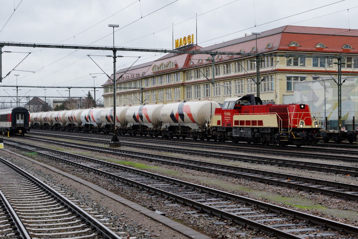 HZL: Die V 180 Gravita 15 L BB mit einem HOLCIM-BLOCKZUG in Singen vor der Kulisse der MAGGI FABRIK, dem Wahrzeichen des Bahnhofs Singen, am 20. November 2015 kurz vor der Abfahrt nach ????
Foto: Walter Ruetsch