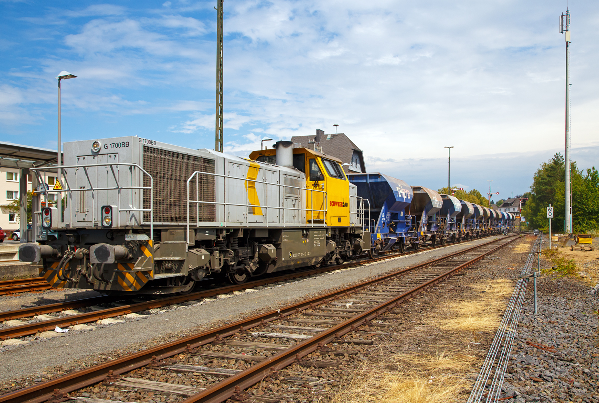 
Im Bauzugdienst....

Die 277 031-1 (92 80 1277 031-1 D-LDS) eine Vossloh G 1700-2 BB der Schweerbau schiebt ihren Schotterzug am 21.07.2018 von Altenkirchen (Ww) in Richtung Au (Sieg). Hinter dem Bahnhof beginnt das Baugleis, die Strecke zwischen Altenkirchen und Au wird z.Z. erneuert.  Blind wird jedoch nicht gefahren, am ersten Wagen steht ein Rangierer der mit Sprechfunk mit dem Lokführer verbunden ist.

Die MaK G 1700-2 BB wurde 2011 unter der Fabriknummer 5001870 bei Vossloh in Kiel gebaut, seit 2012 ist sie Eigentum der Schweerbau, jedoch eingestellt bei LDS GmbH Logistik, Dienstleistungen & Service (Eutin)