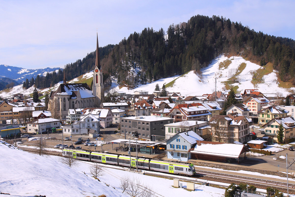 Im Entlebuch: BLS Lötschberger 105 ist als S6 (Luzern - Langnau) in Escholzmatt eingefahren. Die nächste Station wird dann schon im bernischen Emmental sein (das noch luzernische Wiggen ist geschlossen), jenseits einer deutlichen kulturellen, konfessionellen, baulich-architektonischen und sprachdialektischen Grenze. 25.März 2021 