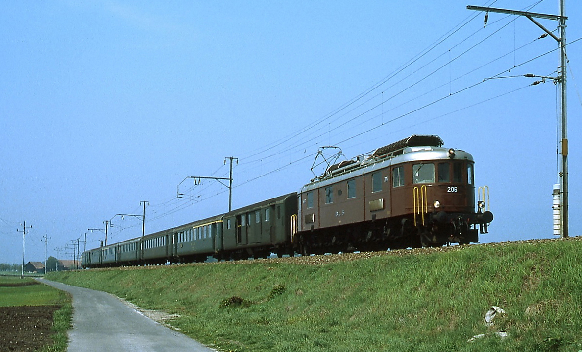 Im Mai 1981 befördert die Ae 6/8 206 der BLS bei Kerzers einen Personenzug von Neuchatel/Neuenburg nach Bern