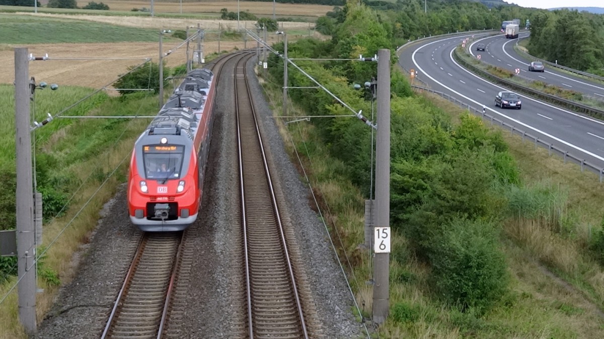 Leicht versp�tet braust am 20.August 2013 dieser 4-teilige Talent2 als RE nach W�rzburg Hbf an den Autos vorbei.