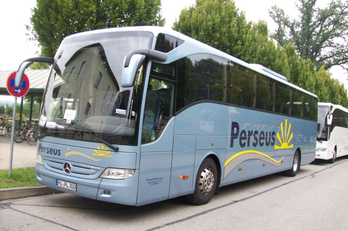 Mercedes-Benz Tourismo RHD M 2 von Perseus-Reisen aus Neumarkt-St. Veit. Dieser 12,96 m lange zweiachsige Reisebus ist Baujahr 2008 und verfügt über 49+1 Mercedes-Benz-Schlafsitze vom Modell 'Travel Star Plus' mit Lederkopfteil und Kurbelarmlehne sowie selbstverständlich über Bordküche und Toilette. Angetrieben wird er von einem Reihensechszylinder Typ MB OM 457 hLA mit 300 kW (408 PS) und einem Sechsgang-Schaltgetriebe Typ MB GO 190-6.
2016 wurde das Fahrzeug verkauft.
Hier steht er am 3. 9. 2012 am Bahnhof in Schwindegg, da er auf einem Schienenersatzverkehr zwischen Schwindegg und Mühldorf/Inn (Bahnstrecke Mühldorf - München) im Einsatz ist.