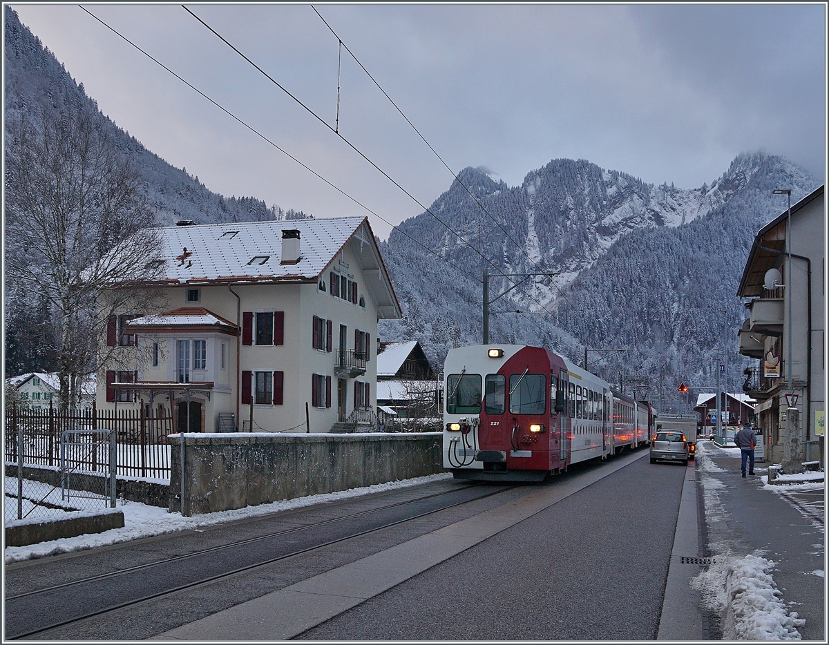 Mit dem Bt 221 an der Spitze verlässt ein TPF Regionalzug nach Bulle Montbovon, wo wie hier zu sehen die Strecke einigen hundert Meter auf der Strasse verläuft. 

3. Dez. 2020