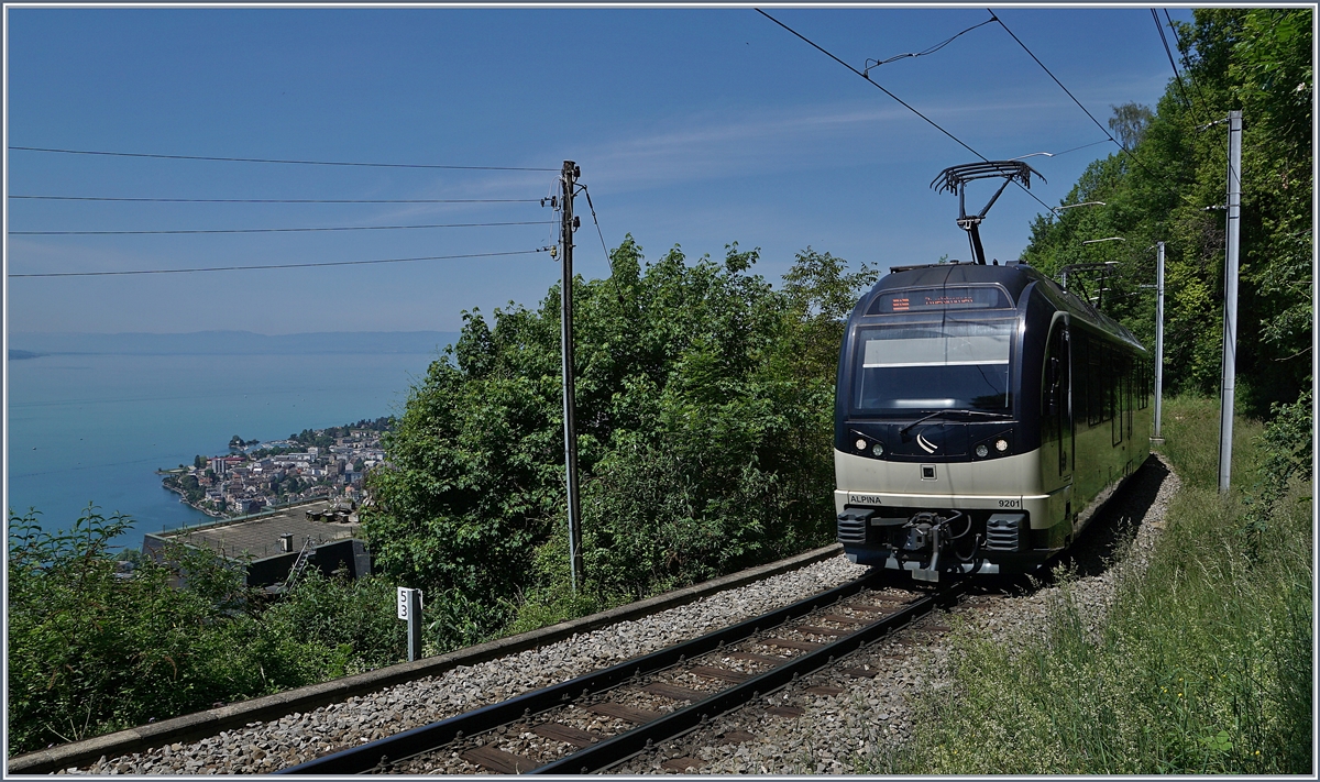 Neben dem Blick auf den nach Montreux fahrenden Be 4/4 9201  Alpina  gleitet der Blick auch über den tief unten liegenden See und die ihn umgebende Landschaft. 
Das Bild entstand bei Sonzier. 

9. Mai 2020