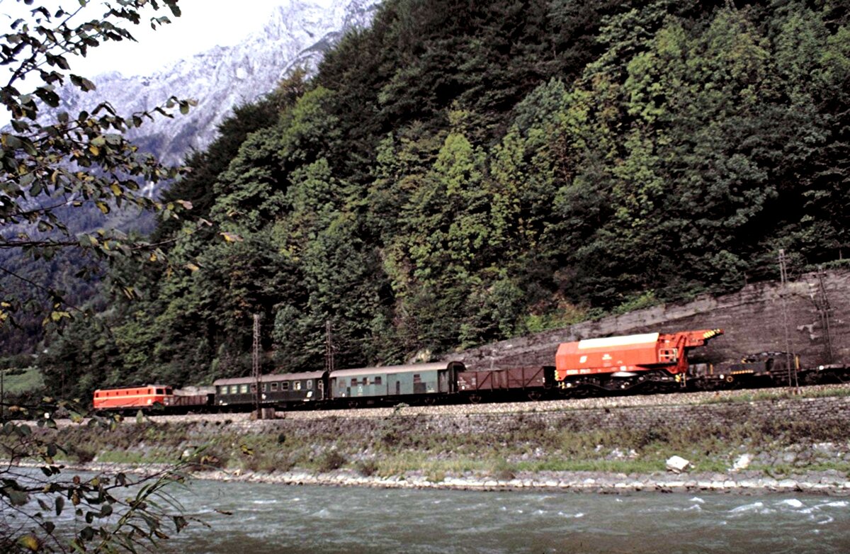 ÖBB 1044 mit Bauzug und Teleskop-Kranwagen bei Bischofshofen neben der Salzach am 03.10.1981.