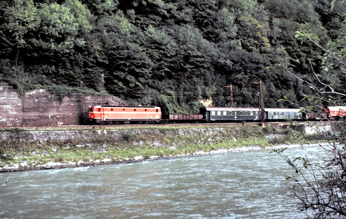 ÖBB 1044 mit Bauzug und Teleskop-Kranwagen bei Bischofshofen neben der Salzach am 03.10.1981.