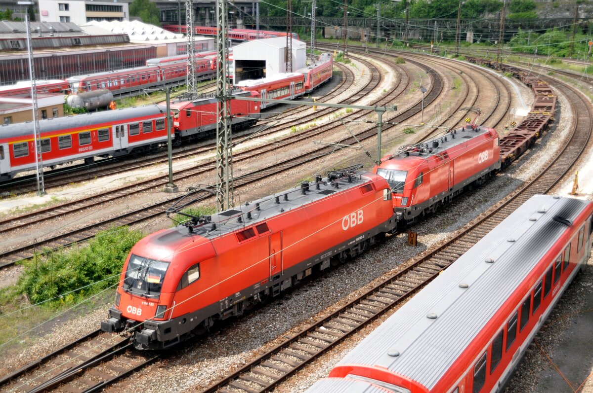 ÖBB 1116 133-0 und 1016 010-8 fahren mit einem langen, leeren Containerzug aus dem Güterbahnhof in Ulm am 09.06.2012.