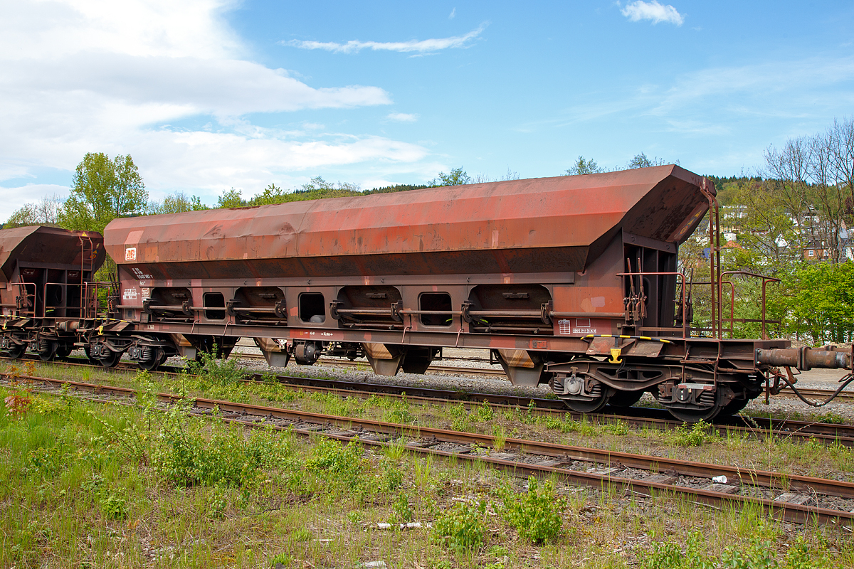Offener Drehgestell-Schüttgutwagen mit dosierbarer Schwerkraftentladung und vier Radsätzen, RIV 31 80 6940 387 D-DB, Gattung Facs 124, der DB Cargo Deutschland AG, abgestellt am 14.05.2017 in Betzdorf/Sieg.   

Die DR lässt zwischen 1978 und 1980 bei ANF Industrie (Frankreich) über 1.450 vierachsige offene Selbstentladewagen mit vier Kammern bauen, die zunächst als Eads-y (5970) eingereiht werden. Bei der DB AG werden die Wagen 1994 in Facs 124 umgezeichnet.

Bei den offenen Selbstentladewagen hat der Laderaum die Form mehrerer nebeneinander stehender Trichter. Der Entladevorgang erfolgt über die Schwerkraft des Ladegutes.
Mehrere Auslauföffnungen mit Drehschiebern ermöglichen die restlose Entladung des Wagens nach der einen oder anderen Seite. Die Menge ist regulierbar - so wie es zum Beispiel für die Entladung über Förderband erforderlich ist. Geeignet sind die Wagen für den Transport nicht nässeempfindlicher Güter in loser Schüttung. Die Drehschieber über einer Einrichtung auf der Bühne an einer Stirnseite des Wagens können einzeln bedient werden.

Der Wagen ist für den Transport von Nässe unempfindlichen Schüttgütern vorgesehen.
Das Untergestell besteht aus miteinander verschweißten Blechen und Walzprofilen. Der Wagenkasten ist eine Schweißkonstruktion und besteht aus vier Trichtern. Querrippen teilen den Wagenkasten in vier Räume, von denen jeder an seinem Unterteil zwei Entladeöffnungen aufweist, die sich an beiden Seiten der horizontalen Mittellinie des Wagens befinden. Über jeder Entladeöffnung ist am Kastenblech eine Stütze für einen Vibrator angeschraubt.
Die acht kreisförmig ausgebildeten Wölbschieber sind auf Rollen gelagert und verschieben sich auf Laufbahnen, die außerhalb der Rinnen angebracht sind. Unter jeder Entladeöffnung sind eine feste und eine schwenkbare Auslaufrutsche angeordnet. Die schwenkbaren Auslaufrutschen werden einzeln durch einen Hebel betätigt, der in der Nähe der Rutsche angebracht ist. Die Betätigung der Wölbschieber erfolgt von der Bedienungsplattform aus.
Die Entladung des Wagens erfolgt nach Öffnen der Schieber durch die Schwerkraft des Ladegutes. Für den Zugang zur Bedienungsplattform sind zwei Auftritte mit Gitterrosten (500 x 160 mm) vorhanden.

Das Entfernen von Ladegutresten in der Be- oder Entladestraße ist nur durch leichte Gummihammerschläge auf die äußeren Behälterwandungen gestattet oder durch den Einsatz von Pressluftlanzen im Laderaum! 

TECHNISCHE DATEN:
Hersteller: ANF Industrie (Frankreich)
Spurweite: 1.435 mm
Achsanzahl: 4 (in 2 Drehgestellen)
Länge über Puffer: 19.040 mm
Drehzapfenabstand: 14.000 mm
Achsabstand im Drehgestell: 1.800 mm
Größe der Beladeöffnung: 1.800 x 15.300 mm
Laderaum:  70 m³
Breite der festen Auslaufrutschen: 600 mm
Breite der schwenkbaren Auslaufrutschen: 476 mm
Wagenhöhe:  4.000 mm
Höchstgeschwindigkeit: 100 km/h (beladen) / 120 km/h (leer)
Maximales Ladegewicht: 56,0 t (ab Streckenklasse C)
Eigengewicht: 23.900 kg
Drehgestell-Bauart: Y 25 Cs – 639
Kleinster bef. Gleisbogenradius: 75 m
Bauart der Bremse:  KE-GP
