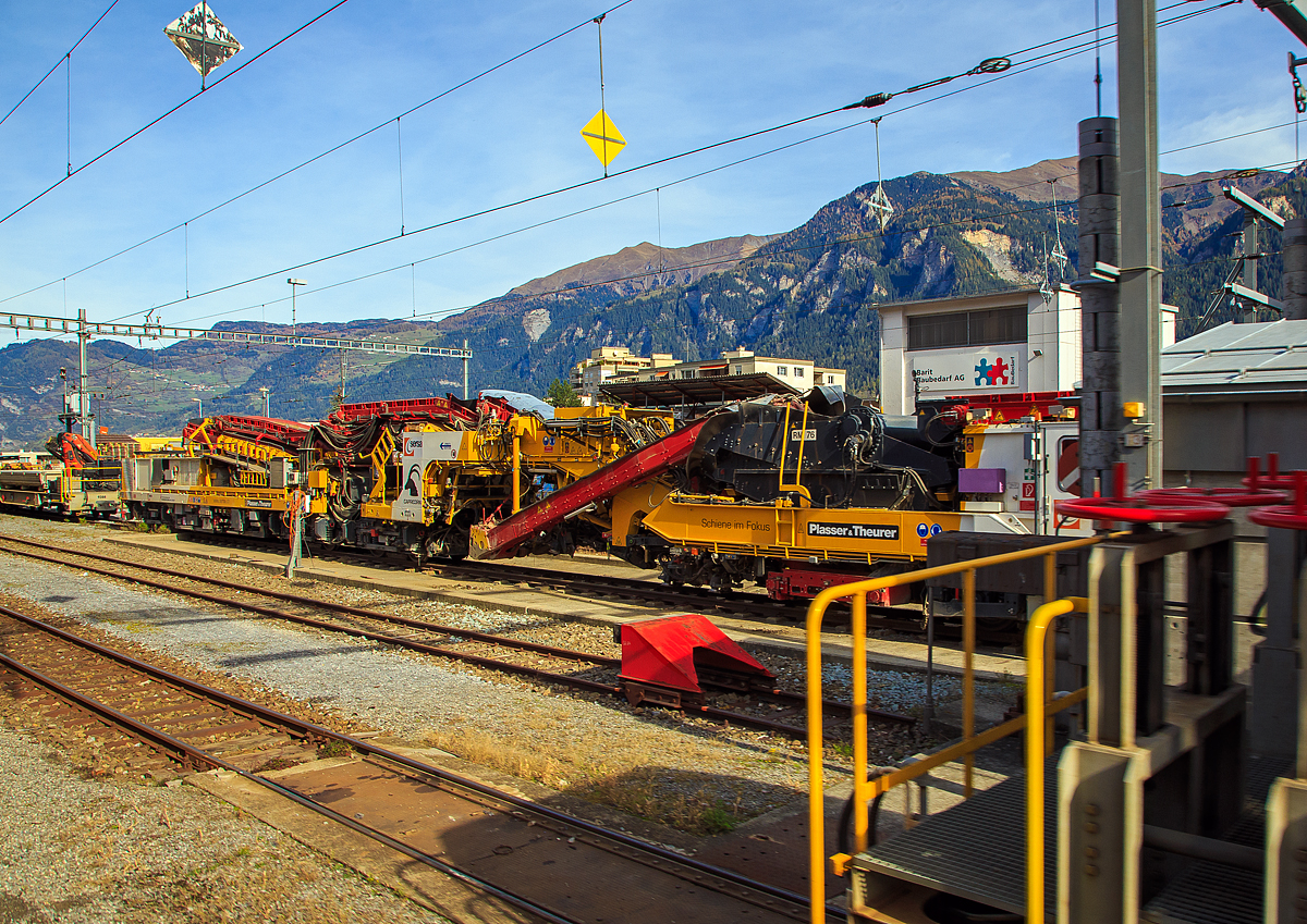 Plasser & Theurer Schotterreinigungsmaschine RM76-SM „CAPRICORN“ (98 78 9 501 561-6 SERSA-CH) der Sersa Maschineller Gleisbau AG steht am 01.11.2019 im Bahnhof Thusis (aufgenommen aus einem Zug heraus). Leider hier nicht ganz komplett im Bild.

Für die Optimierung der Streckenerneuerung im Meterspurbereich bekam die Sersa Maschineller Gleisbau AG (Rhomberg Sersa Rail Group) 2016 die neuen Schotterreinigungsmaschine RM76-SM „CAPRICORN“ von Plasser & Theurer.

Die neue Schotterreinigungsmaschine RM76 CAPRICORN wurde basierend auf der langjährigen Betriebserfahrung der Experten der Sersa Maschineller Gleisbau AG und dem Fachwissen des österreichischen Maschinenherstellers Plasser&Theurer entwickelt und erbaut. Die Maschine ist speziell für den Einsatz im Meterspurbereich konzipiert und trägt den Namen „CAPRICORN“ zu Recht, bewältigt sie doch Steigungen bis zu70 Promille und Kurvenradien bis 45 Meter problemlos, so ist sie auch auf der Berninabahn einsetzbar. Sie windet sich an Felsen entlang und durchquert enge Tunnels bis zum Firn und Eis der Hochalpen.

Bei der Maschinenkonstruktion wurden verschiedene Modifikationen und Innovationen wie die Neuschotterzuführung aus einem angehängten Silowagen, die Planumsglättung und der Einbau von Geotextil realisiert. Zusammen mit der Planier- und Verdichtungsmaschine R20RD ist nun im Meterspurbereich eine moderne und effiziente Maschinenkombination im Einsatz. Alle bisherigen Einsätze verliefen ausnahmslos erfolgreich, bewiesen aber einmal mehr deutlich, dass die Verhältnisse bei den Schweizer Gebirgsbahnen mit jenen bei normalspurigen Bahnen in Europa nicht vergleichbar sind. Sind doch beispielsweise große Steine und alte Fundamente auf Gebirgsstrecken eher die Regel als die Ausnahme. Die Investitionen in die Entwicklung und Realisierung der CAPRICORN zugunsten einer Effizienzsteigerung von Einsätzen im Meterspurbereich sind deshalb gerechtfertigt.

Systembeschreibung
Die Schotterreinigungsmaschine RM76 CAPRICORN fördert mittels einer Kette den Schotter in die Siebanlage. Der gereinigte Schotter wird wieder in das Gleisbett eingebracht. Dieses effiziente Verfahren schont die Umwelt und Ressourcen gleichermaßen. Der verschmutzte Abraum wird auf Altschotterwagen gefördert und abtransportiert. Die RM76 CAPRICORN in Kombination mit dem Portalkransystem MUNGG ermöglicht ganze Streckenerneuerungen (inklusive Gleis- und Schwellenersatz) auch in der Nachtsperre.

Für den Abschluss der Arbeiten kommen Stopf- und Planiermaschinen zum Einsatz.

TECHNISCHE DATEN:
Spurweite: 1.000 mm (Meterspur)
Anzahl angetriebene Achsen: 8
Länge über Puffer: 35.500 mm
Eigengewicht: 124 t
Antriebsleistung: 839 kW	
Höchstgeschwindigkeit Eigenfahrt und geschleppt: 60 km/h
Min. Kurvenradius: 45 m
Bremssystem: Druckluft und Vakuum
Arbeitsgeschwindigkeit 150-180 m/h
Arbeitsleistung typisch: 300 m³/h
Schotterbett (Breite 4 m / Volumen 1,8-2 m³/m)
Aushubbreite minimal: 2.6 m
Aushubbreite maximal: 4.2 m
Schotterreinigung: Sieb mit 3 Decks
Wassersprühanlage: ja

Quelle: Sersa Group AG
