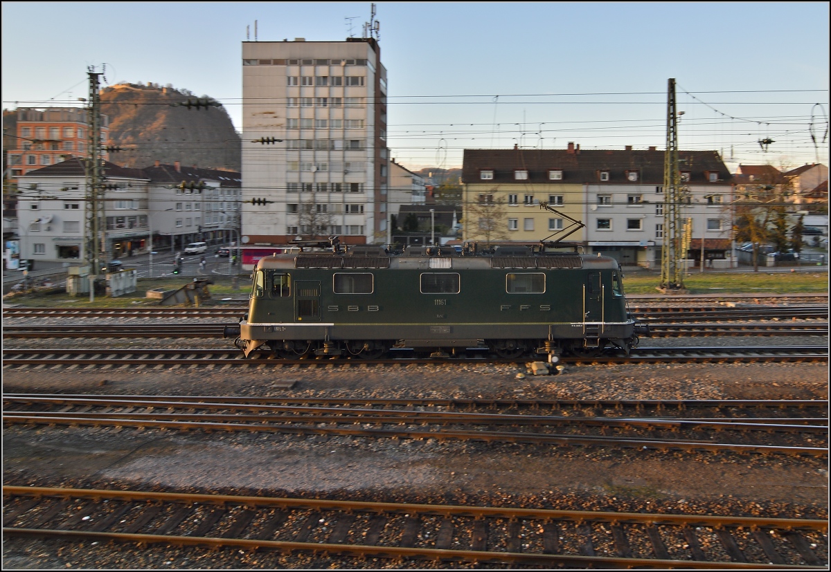 Re 4/4 II 11161 im grünen Farbkleid setzt sich vor auf IC 187 nach Zürich. November 2013.