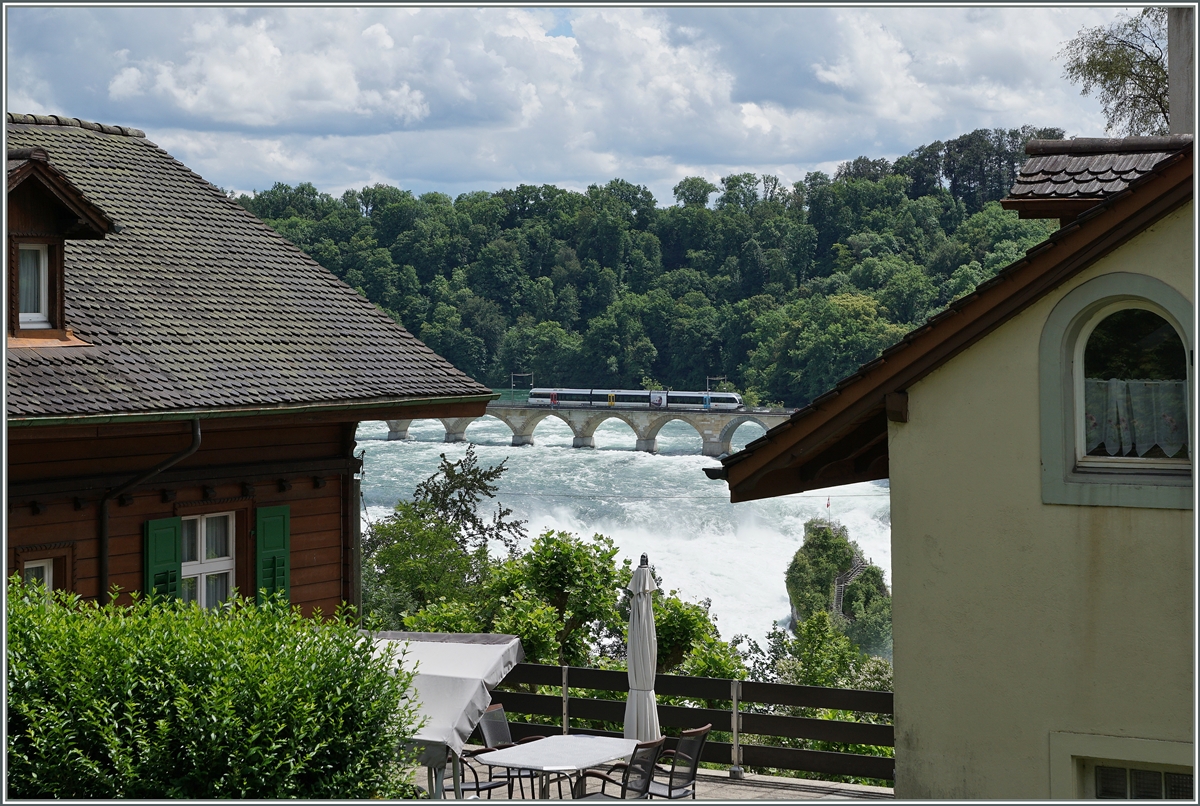 Rheinfall - ein Nischennbild gibt den Blick frei auf den Rheinfall und eine Thorbo GTW welcher die Rheinbr�cke bei Neuhausen �berquert.

18. Juni 2016