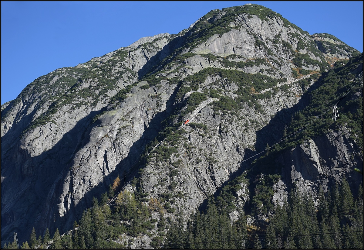 Rot leuchtet hier der Wagen der Gelmerbahn. Die Standseilbahn ist mit bis zu 106% Steigung teilweise eher ein Aufzug denn eine Bahn... Ohne die rot leuchtende Farbe wäre das Bähnchen vor den Gelmerhörnern kaum zu sehen. Guttannen, Oktober 2017.