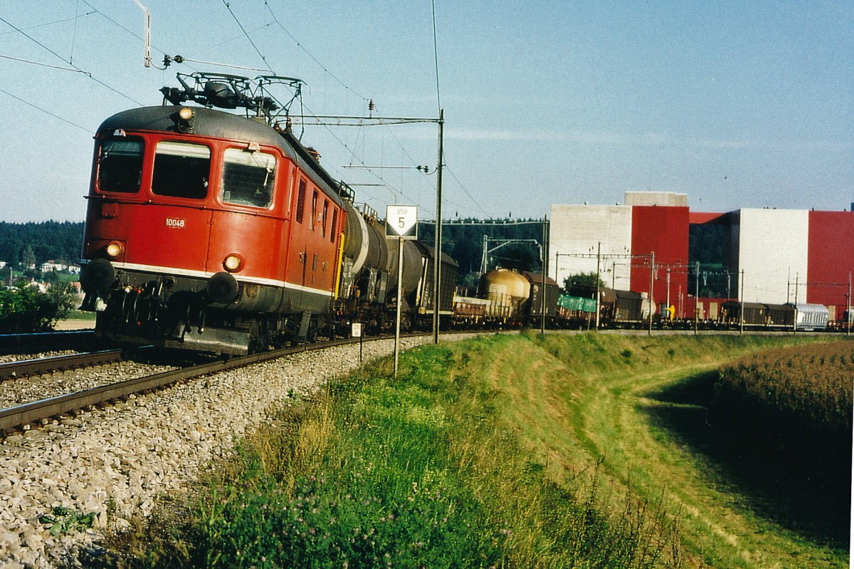SBB: G�terzug B�ren an der Aare-Lyss-Biel mit Re 4/4 | 10048 im Sommer 1997 in der Fotokurve bei Busswil.
Foto: Walter Ruetsch