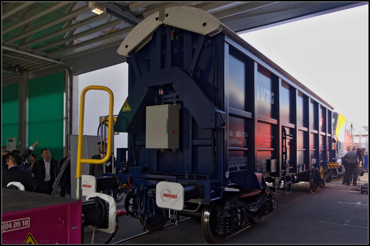 Schmal sieht der vierachsige Güterwagen mit öffnungsfähigen Dach der Gattung Tamns aus und doch entspricht der Wagen dem Lichtraumprofil G1. Über das pneumatisch, ferngesteuert oder per Smartphone zu öffnene Dach kann Schüttgut aller Art transportiert werden. Die Innenseite ist wasserdicht und der Rumpf verstärkt. Ausgestellt war der Wagen während der Innotrans 2018 in Berlin (37 TEN 80 VTG 0806 039-4 Tamns).
<br><br>
Technische Daten: Nutzlast 68 t, Eigengewicht 22 t, Volumen 50 m3, Kennzeichnung TEN-GE, max. Geschwindigkeit beladen 120 km/h, LüP 13 040 mm, Achslast 25 t.