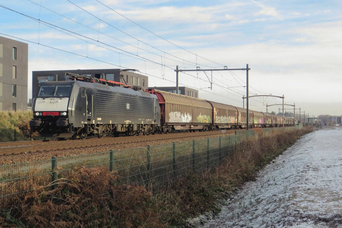 Sechsehn geschlossene Wagen zieht MRCE 189 099 durch Tilburg-Reeshof am 22 Dezember 2021.