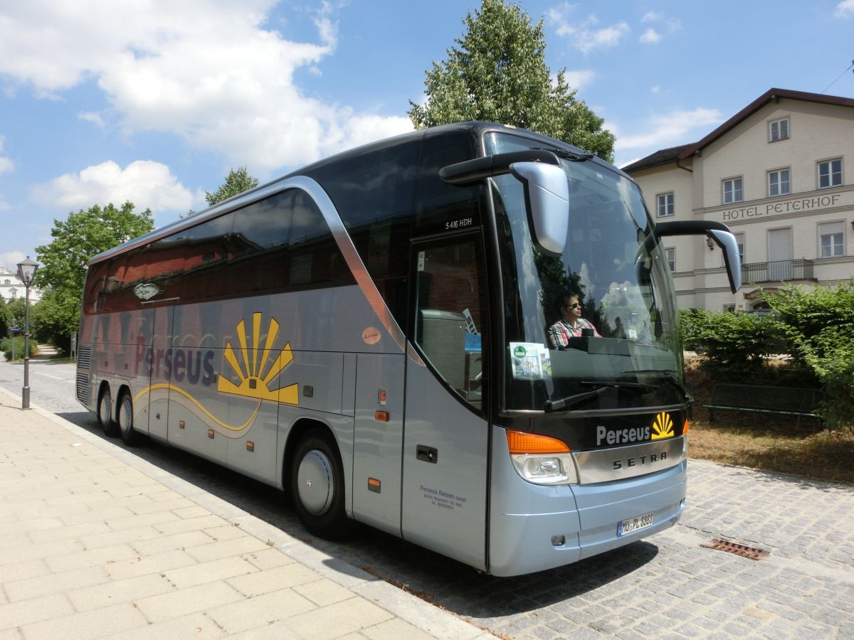 Setra S 416 HDH der '100 Jahre Otto Kässbohrer Edition' von Perseus-Reisen aus Neumarkt-St. Veit. Anlässlich des 100. Geburtstags von Otto Kässbohrer gab es ab 2003 eine auf 100 Exemplare limitierte Sonderserie der Setra TopClass 400. Dieses Fahrzeug wurde 2003 gebaut und ist mit 50+1 Schlafsesseln vom Modell 'Top' in Ambiente-Polsterung mit Lederkopfteil (in der üblichen 2-2-Bestuhlung das Topmodell) sowie natürlich mit Bordküche und Toilette ausgestattet. Als Antrieb dient ein V8 Typ MB OM 502 LA mit 350 kW (476 PS) (Leistung per Chiptuning gesteigert) und das automatisierte Zwölfgang-Schaltgetriebe ZF 12 AS 2300 B.
Bis 2012 gab es bei Perseus einen weiteren, identischen S 416 HDH.
Diese Aufnahme entstand am 15. 7. 2015 vor dem Bahnhof in Neumarkt-St. Veit, als der Reisebus gerade eine Tour auf der RBO-Linie 7517 gefahren war.