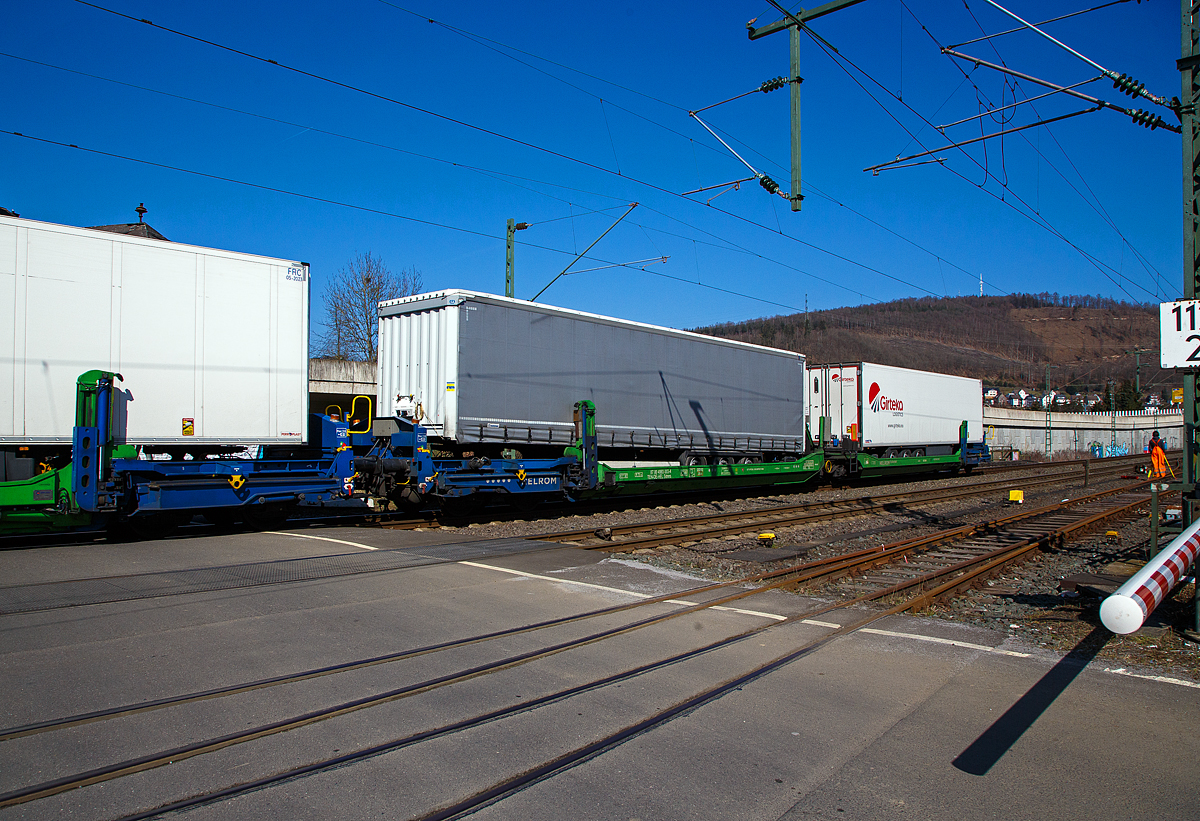 Spezieller sechsachsiger Gelenk-Taschenwagen System HELROM, 87 80 4993 003-4 D-HEL, der Gattung Sdmrs, der HELROM Trailer Rail am 24.03.2021 im Zugverband bei der Durchfahrt in Niederschelden. 

Der Clou bei HELROM sind neuartige Transportwaggons, die keine teuren Kran- oder Verladeeinrichtungen brauchen. Dieses Megaswing-System ist ein spezieller Taschenwagen mit schwenkbaren Aufnahmewannen fr Sattelauflieger. Hydrauliksttzen dienen als Stabilisierung, wenn die Wanne nach links oder rechts ausschwenkt. Die Beladung der Wanne mit einem Sattelauflieger erfolgt rckwrts. Nach Absatteln des Sattelaufliegers wird die Wanne angehoben und schwenkt wieder ein. Der Sattelauflieger wird leicht abgesenkt und mit dem Waggon fest verbunden, er ist nun auf dem Waggon sicher verstaut. Die Technik ist im Waggon verbaut.

TECHNISCHE DATEN:
Hersteller: Gk Yapi  (Trkei)
Spurweite: 1.435 mm
Lnge ber Puffer:	34.230 mm
Drehzapfenabstand: 2 x 14.200 mm
Achsabstand im Drehgestellen: 1.800 mm
Laufraddurchmesser: 920 mm (neu)
Eigengewicht: 45.200 kg 
Max. Zuladung bei Lastgrenze: 76,0 t (ab Streckenklasse D)
Max. Geschwindigkeit: 100 km/h (beladen) / 120 km/h (leer)
Kleinster befahrbarer Gleisbogen: R 75 m
Bremse: 2 x MH-GP-A (K)
Bremssohle: Cosid 810
Feststellbremse: Ja (auf ein Drehgestell)
Intern. Verwendungsfhigkeit: TEN CW
