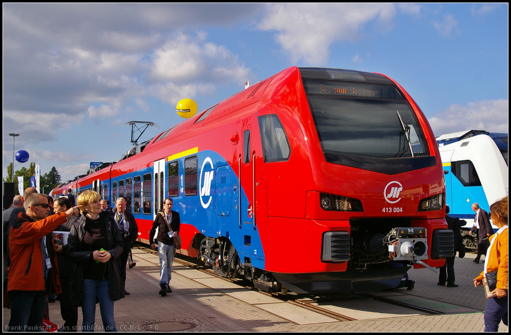 Stadler FLIRT3 for Serbia.
<br /><br />
Die serbische �eleznice Srbije (�S) haben auf der InnoTrans 2014 in Berlin den bereits 2013 bestellten FLIRT3 vorgestellten elektrischen Triebzug vorgestellt. Insgesamt wurden 21 Z�ge f�r den S-Bahn-Verkehr bestellt. Ausgestellt war 413 004-3 auf dem Freigel�nde (NVR-Nummer 94 72 0 413 004-3 SRB-�S)
<br /><br />
Daten: Spannung 25 kV/50 Hz, H�chstgeschwindigkeit 160 km/h, bis zu 3-fach-Traktion m�glich, Sitzpl�tze 234, Multifunktionsabteile, Nachr�stung auf ETCS 2 m�glich.
