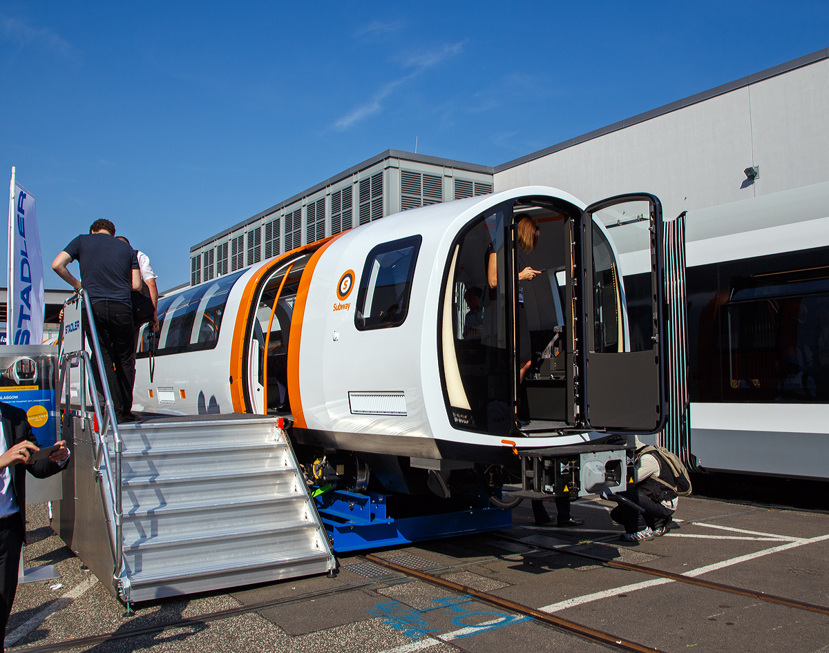 Stadler prsentierte auf der InnoTrans 2018 (hier 19.09.2018) in Berlin einen der 17 neuen fr die Glasgow Subway bestimmten Metrozge (METRO GLASGOW EMU). Leider war die ganze Messe so sehr berlaufen, das mehr Fotos nicht mglich waren.

Strathclyde Partnership for Transport  (SPT) hat im Mrz 2016 im Rahmen des Modernisierungsprogrammes fr das U-Bahn-System in Glasgow 17 neue Metrozge fr rund 200 Millionen Pfund bei Stadler bestellt. Glasgow Subway ist das viertlteste Metrosystem der Welt. Die Erffnung der Glasgower U-Bahn war im Dezember 1896. 

Obschon das Tunnelsystem aus viktorianischer Zeit einen sehr engen Durchmesser hat, ist es Stadler gelungen, ein kompaktes Fahrzeug zu bauen, das den Bedrfnissen anspruchsvoller Fahrgste gerecht wird. Der vorhandene Innenraum wird optimal ausgenutzt und bietet auch Platz fr Rollsthle. Das Interieur ist offen und freundlich gestaltet. Das neu entwickelte Drehgestell mit Luftfederung trgt zu einem komfortableren Fahrerlebnis bei. Die Fahrzeuge sollen vollautomatisch und fahrerlos fahren. Sie haben noch einen temporren Fhrerstand fr die Migrationsphase und ein Hilfsfhrerpult fr Rangierfahrten und Notbetrieb mit den bestehenden Fahrzeugen. 

Die Zge verkehren automatisch, die Aufgaben des Fahrers beschrnken sich darauf, die Tren zu schlieen und den Zug in Bewegung zu setzen. Sie tragen zum Teil die ursprngliche orangefarbene Lackierung, teilweise sind sie in den Farben der SPT lackiert. Zum hundertjhrigen Jubilum der Bahn erhielt der Wagen 122 eine wei/braune Livree hnlich der der ersten Kabelbahnwagen[5], ein Beiwagen wirbt in hellblauer Farbgebung fr die 2014 in der Stadt ausgetragenen Commonwealth Games.

Ein Triebzug besteht aus zwei Halbzgen mit identischer Antriebsausrstung. Die Wagenksten sind aus Aluminium-Strangpressprofilen gefertigt und laufen auf luftgefederten Motor- und Laufdrehgestellen. Die Fahrzeuge haben durchgngig die gleiche Fubodenhhe im gesamten Fahrgastraum und besitzen einen grozgigen Mehrzweckbereich. Ein Halbzug besteht aus aus vier Wagenksten mit sechs Drehgestellen, die beiden Mittelwagenksten mit nur einem Drehgestell sind auf die Endwagen aufgesattelt. Fr den raschen Personenfluss, hat ein Halbzug sechs Einstiegstren je Seite. Die Energieversorgung der Fahrzeuge erfolgt ber eine dritte Schiene mit 600 V DC. Die Fahrzeuge sind fr eine Hchstgeschwindigkeit von 58 km/h ausgelegt.

TECHNISCHE DATEN, je Halbzug:
Spurweite: 1.220 mm
Speisespannung:  600 V DC (ber dritte Schiene)
Achsanordnung Bo'Bo'+ 2' + 2'+ Bo'Bo'
Inbetriebsetzung: 2020
Lnge ber Kupplung: 3.9240 mm
Fahrzeugbreite: 2.340 mm
Fahrzeughhe: 2.650 mm
Achsabstand im Drehgestell: 1.650 mm
Treib- und Laufraddurchmesser: 540 mm (neu)
Dauerleistung am Rad: 520 kW
Maximale Leistung am Rad: 820 kW
Anfahrzugkraft (bis 23 km/h): 130 kN
Anfahrbeschleunigung brutto: 1,3 m/s
Hchstgeschwindigkeit: 58 km/h
Bodenhhe: 695 mm
Einstiegsbreite: 1.200 mm
Sitzpltze: 104 und 6 Klappsitze
Stehpltze bei 6 Pers./m: 199

Die Glasgow Subway ist die U-Bahn der grten schottischen Stadt Glasgow. Sie wurde 1896 erffnet und war damals nach den U-Bahnen in London, Liverpool und Budapest das viertlteste U-Bahn-System der Welt. Sie besteht lediglich aus einer vollstndig im Tunnel verlaufenden Ringstrecke und wurde seit der Erffnung nie erweitert. Betrieben wird sie von der Strathclyde Partnership for Transport (SPT), zusammen mit den Vorortlinien der Eisenbahn bildet sie das Schnellbahnnetz Glasgows.

Die 10,5 Kilometer lange Ringstrecke mit 15 Stationen verluft vollstndig unterirdisch, nur der Betriebshof bei Govan, im Sdwesten, liegt an der Oberflche. Sie verbindet die Innenstadt Glasgows mit dem West End und den sdwestlichen Vororten sdlich des Flusses Clyde. Die Strecke wird von Zgen zweier gegenlufiger Linien befahren. Sie wird im Linksverkehr betrieben, die Fahrten auf dem ueren Ringgleis (outer circle) mit der Kennfarbe Orange erfolgen im Uhrzeigersinn, die auf dem inneren Ringgleis (inner circle) mit der Kennfarbe Grau entgegen dem Uhrzeigersinn. Die Zge verkehren werktags zwischen 6:30 Uhr und 23:30 Uhr in Abstnden von vier bis acht Minuten, sonntags von 10:00 Uhr bis 18:00 Uhr alle acht Minuten.

Die Fahrzeuge laufen auf Schmalspurgleisen mit der ungewhnlichen Spurweite von 1.219 mm beziehungsweise vier Fu. Ihren Strom beziehen die Zge ber eine seitliche Stromschiene, deren Spannung bei 600 Volt liegt. Die Tunnel mit einem Durchmesser von lediglich 3,35 Metern befinden sich oft knapp unter der Erdoberflche, sie folgen hufig den Straenverlufen. Jene Streckenabschnitte, die die Flsse Clyde und Kelvin oder Bahnstrecken unterqueren, liegen tiefer und sind mit Gusseisentbbings verkleidet. Sie machen etwa ein Drittel der Strecke aus. Die Tunnelwnde der beiden Fahrtrichtungen liegen rund 0,75 bis 1,8 m voneinander entfernt. Der Streckenverlauf weist Steigungen von bis zu sechs Prozent auf. Tiefste Station ist Buchanan Street, die zwlf Meter unter der Oberflche liegt.

Quellen: Stadler Rail und Wikipedia (ber die U-Bahn selbst)

