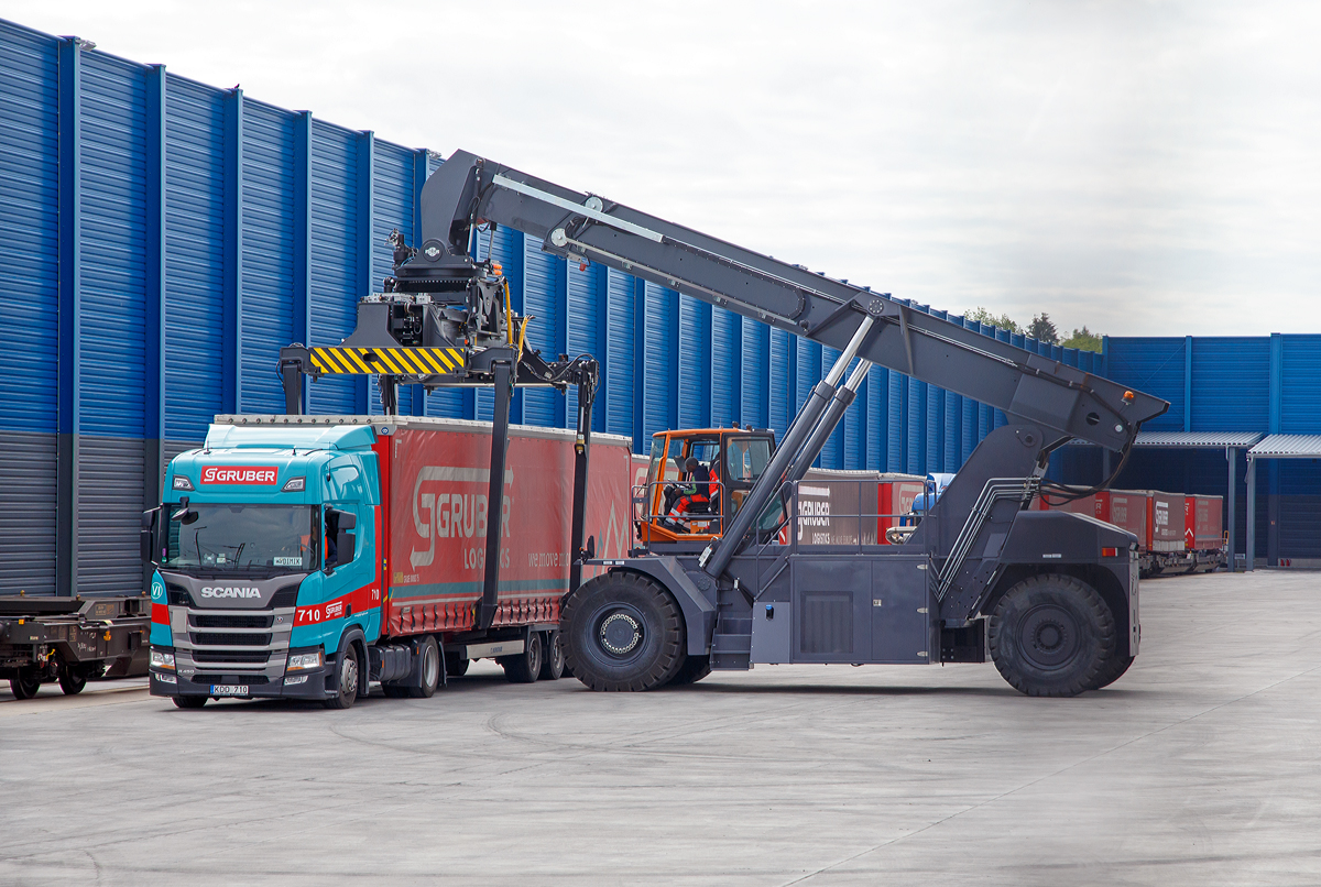 
Südwestfalen Container-Terminal GmbH (SWCT), Kreuztal Ubf, den 31.05.2019:
Die Entladung der Gelenk-Taschenwagen der Gattung Sdggmrs (Typ T3000e).  Die Sattelauflieger (Sattelanhängern) werden nach und nach mittels Reachstacker bzw. Greifstapler aus den Gelenk-Taschenwagen gehoben und sofort an die Sattelzugmaschine angehangen.
